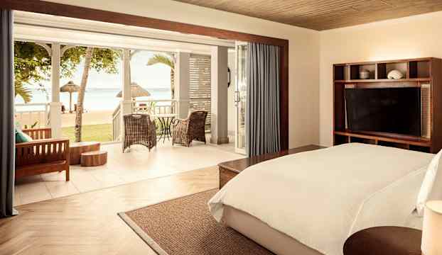 Sovrum med dubbelsäng och havsutsikt från terrassen. (AI-genererad text)