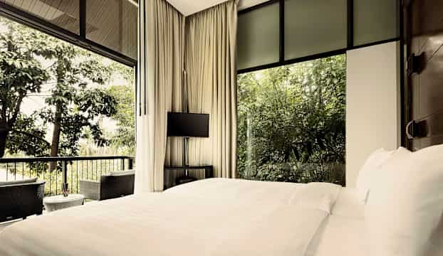 Hotellrum med stora fönster som vetter mot grönska. (AI-genererad text)