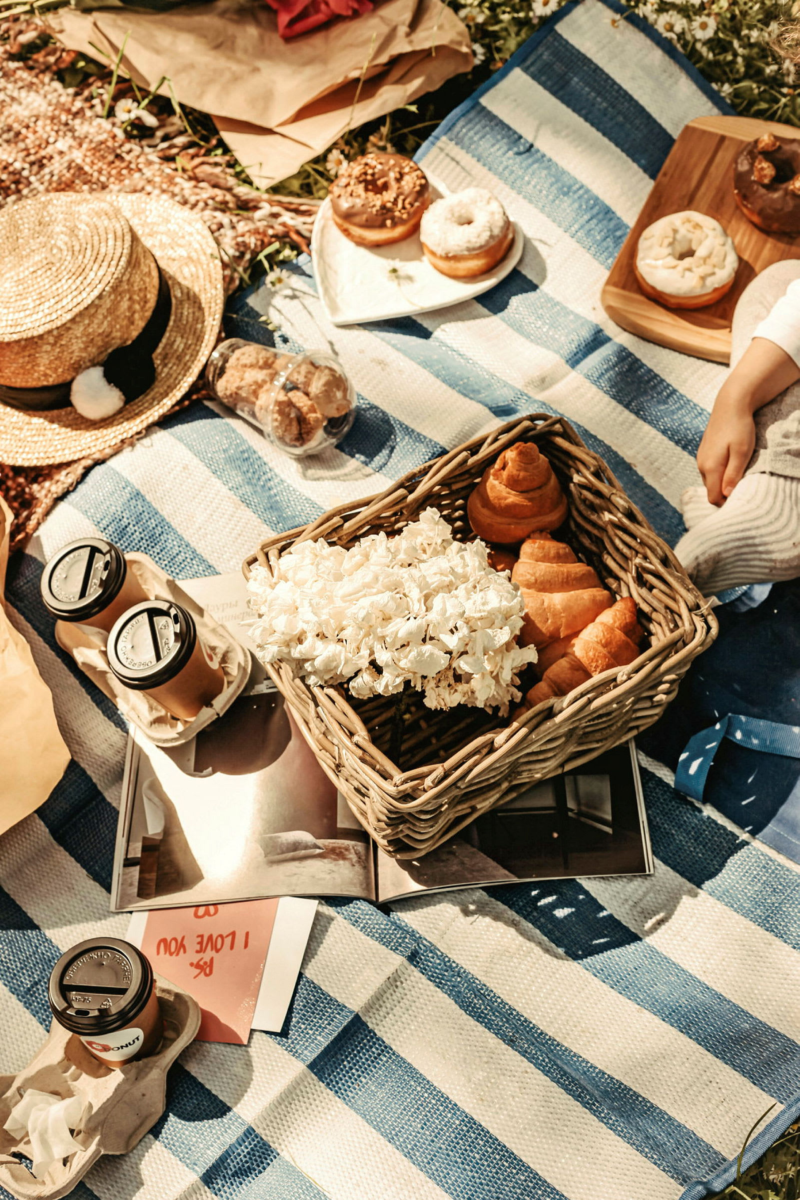 Picknick på filt med hatt, croissanter och kaffe. (AI-genererad text)