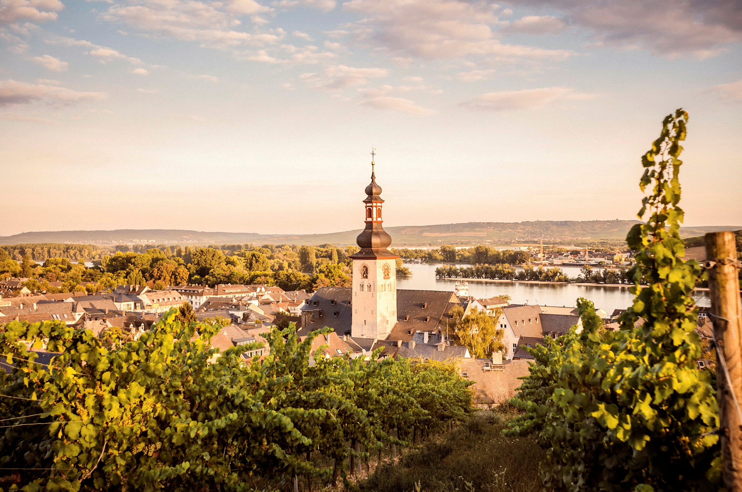 Vy över en liten stad med en kyrka och omgivande landskap. (AI-genererad text)