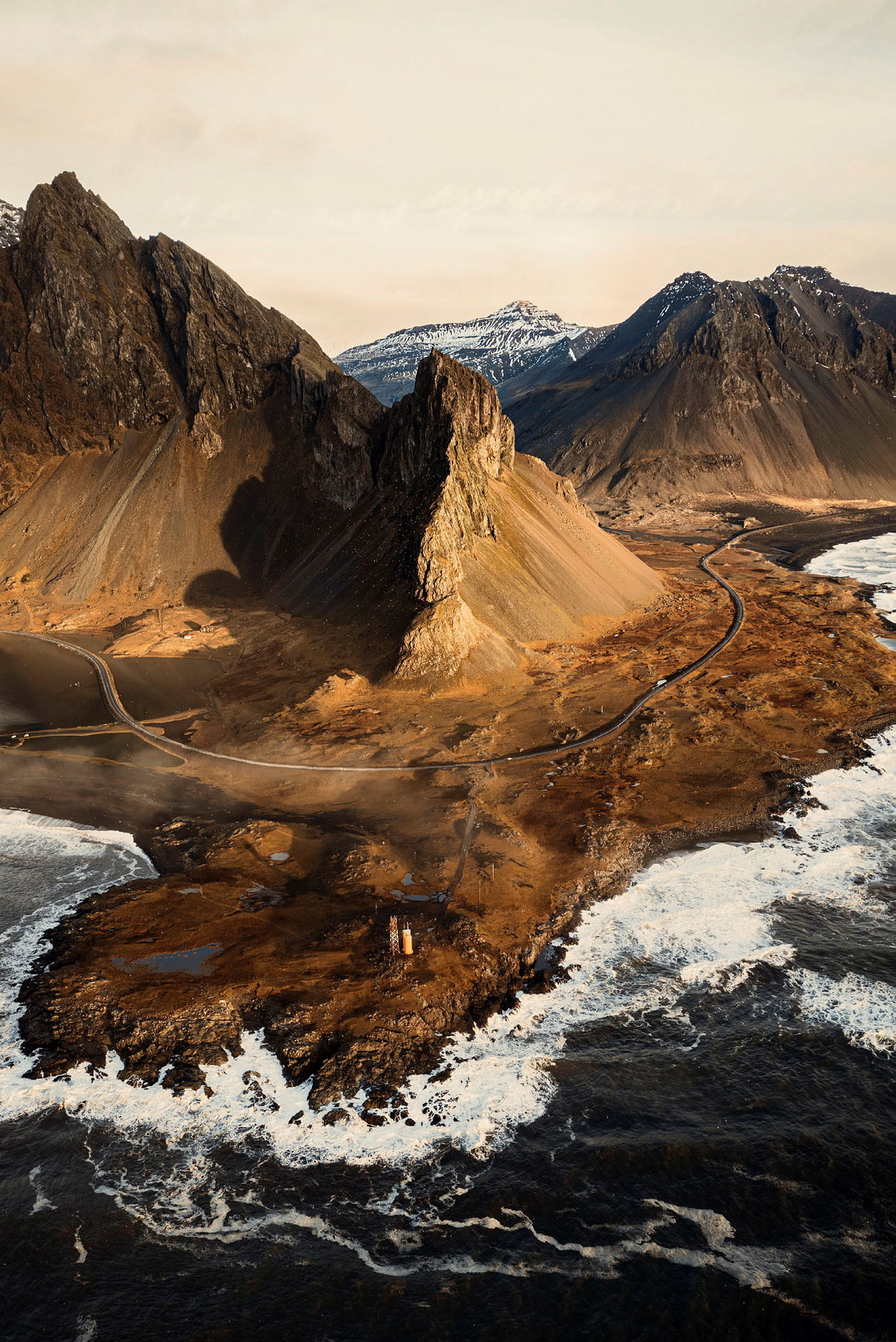 En kustlinje med klippor, en väg och berg i bakgrunden. (AI-genererad text)