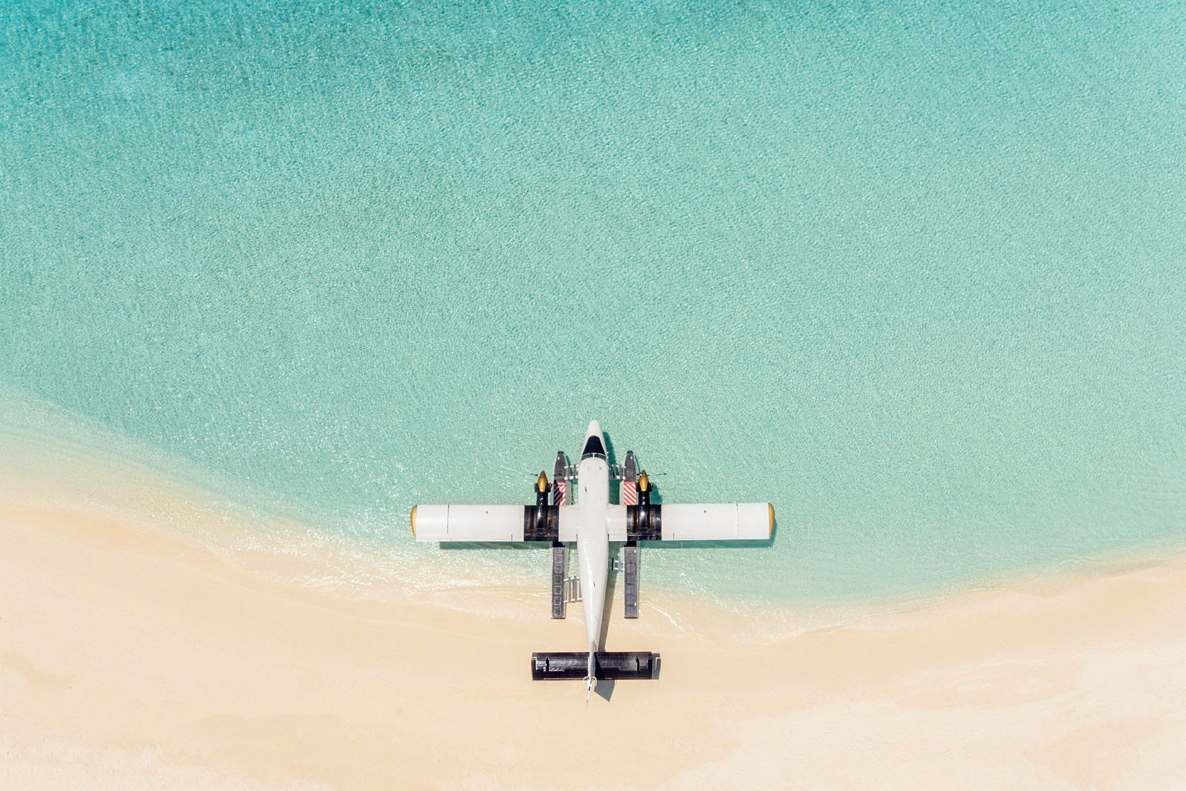 Flygplan vid en strand med turkost vatten. (AI-genererad text)