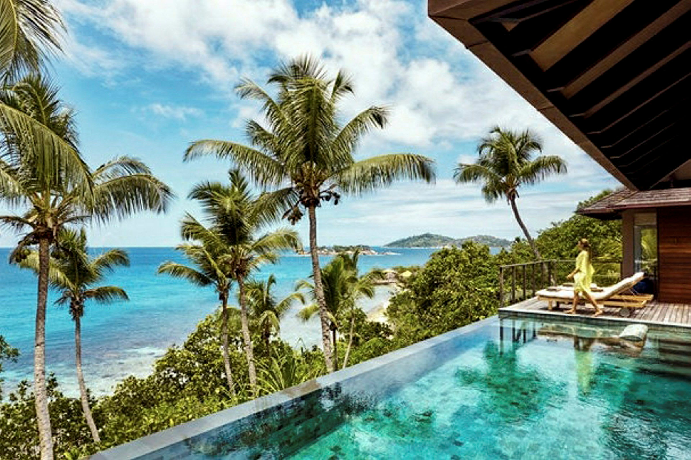 Infinitypool med utsikt över tropiskt landskap med palmer och hav. (AI-genererad text)
