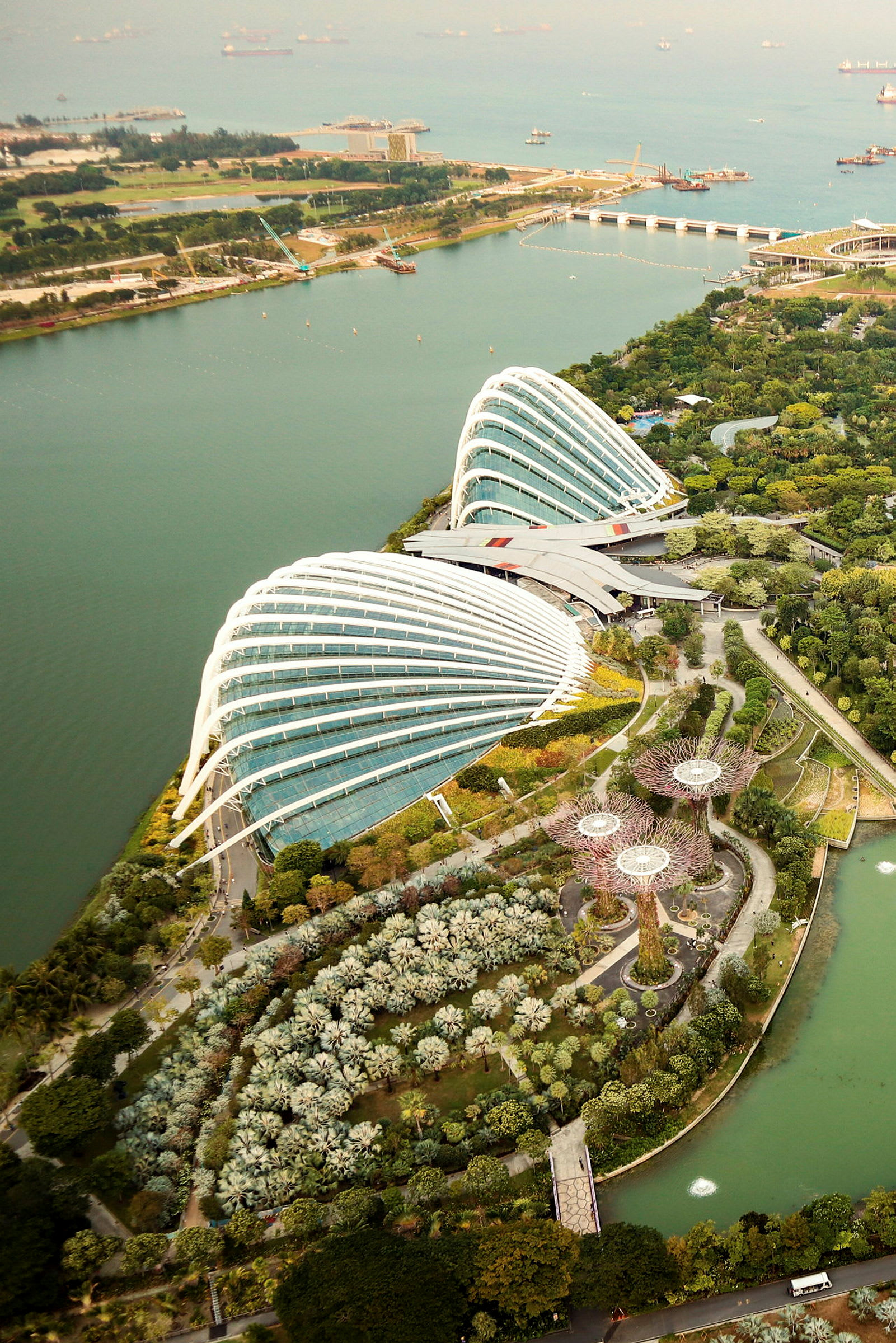 Flygbild över Gardens by the Bay i Singapore, med dess ikoniska glaskupoler och grönskande trädgårdar vid vattnet. (AI-genererad text)