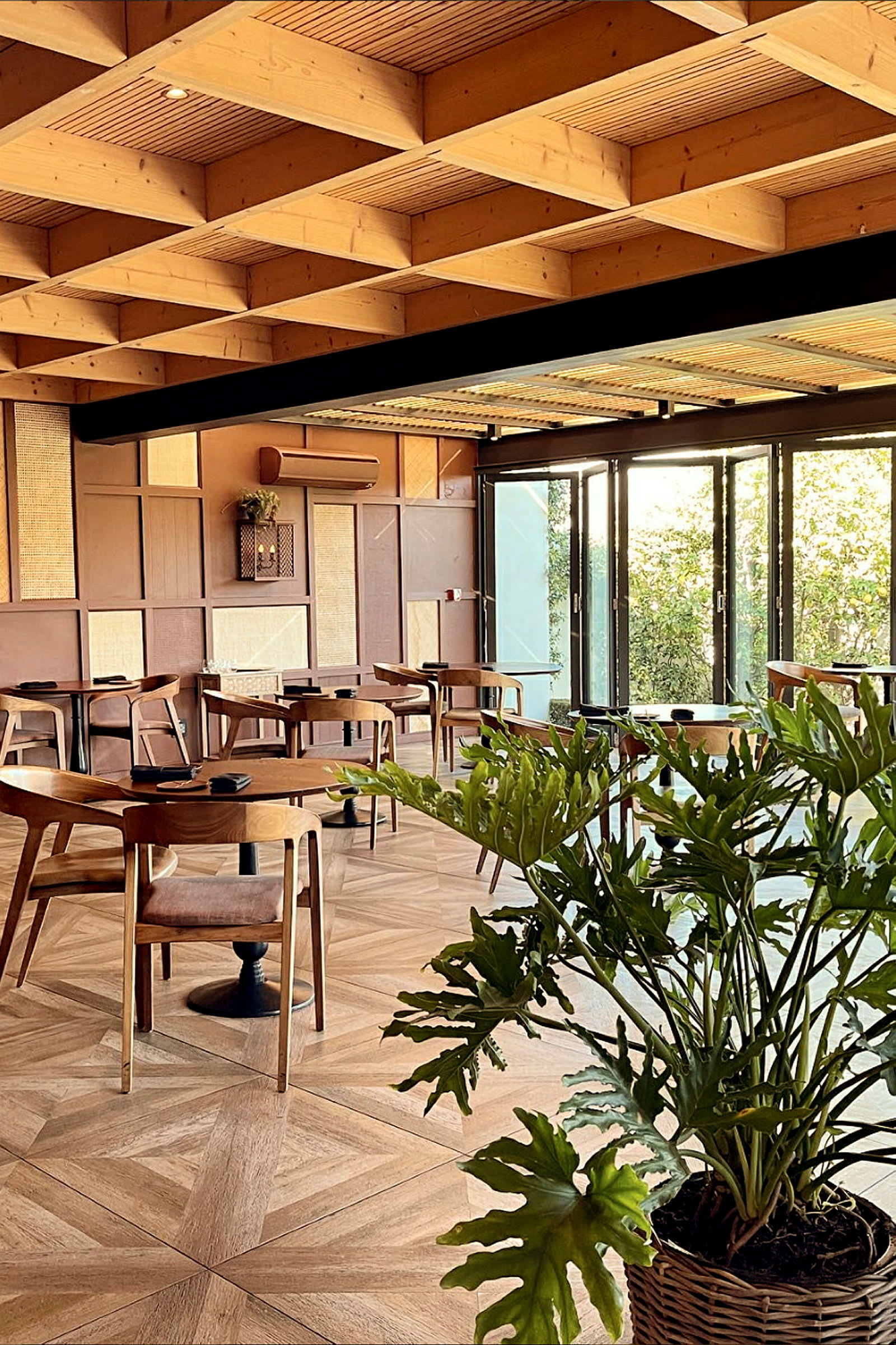 En modern restaurang med träbord, stolar och växtdekorationer. (AI-genererad text)
