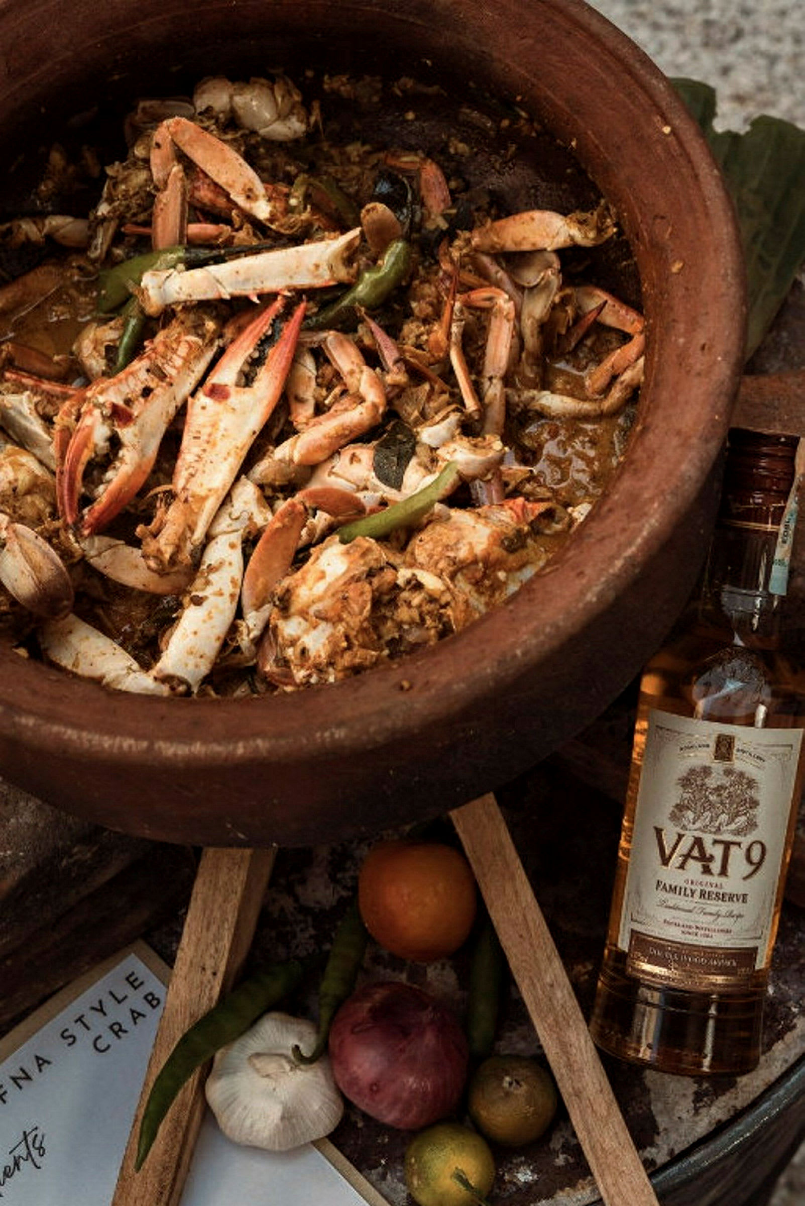 Lergodsgryta med krabbkött och grönsaker samt en flaska whisky intill. (AI-genererad text)