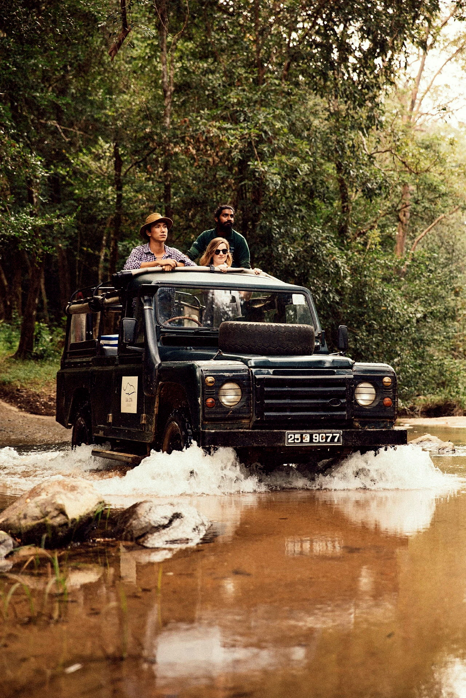 En jeep kör genom vatten i en skog. (AI-genererad text)