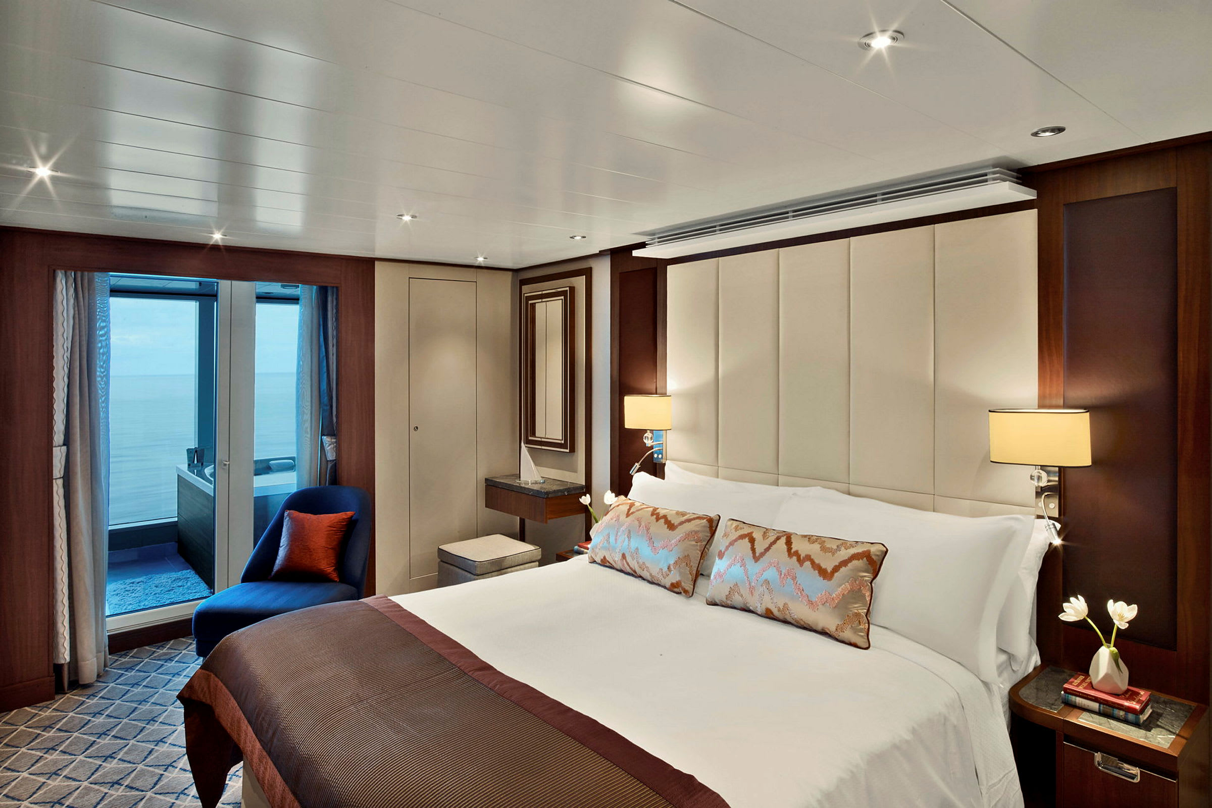 Ett elegant hotellrum med en stor säng, inredning i neutrala färger och en balkong med utsikt. (AI-genererad text)