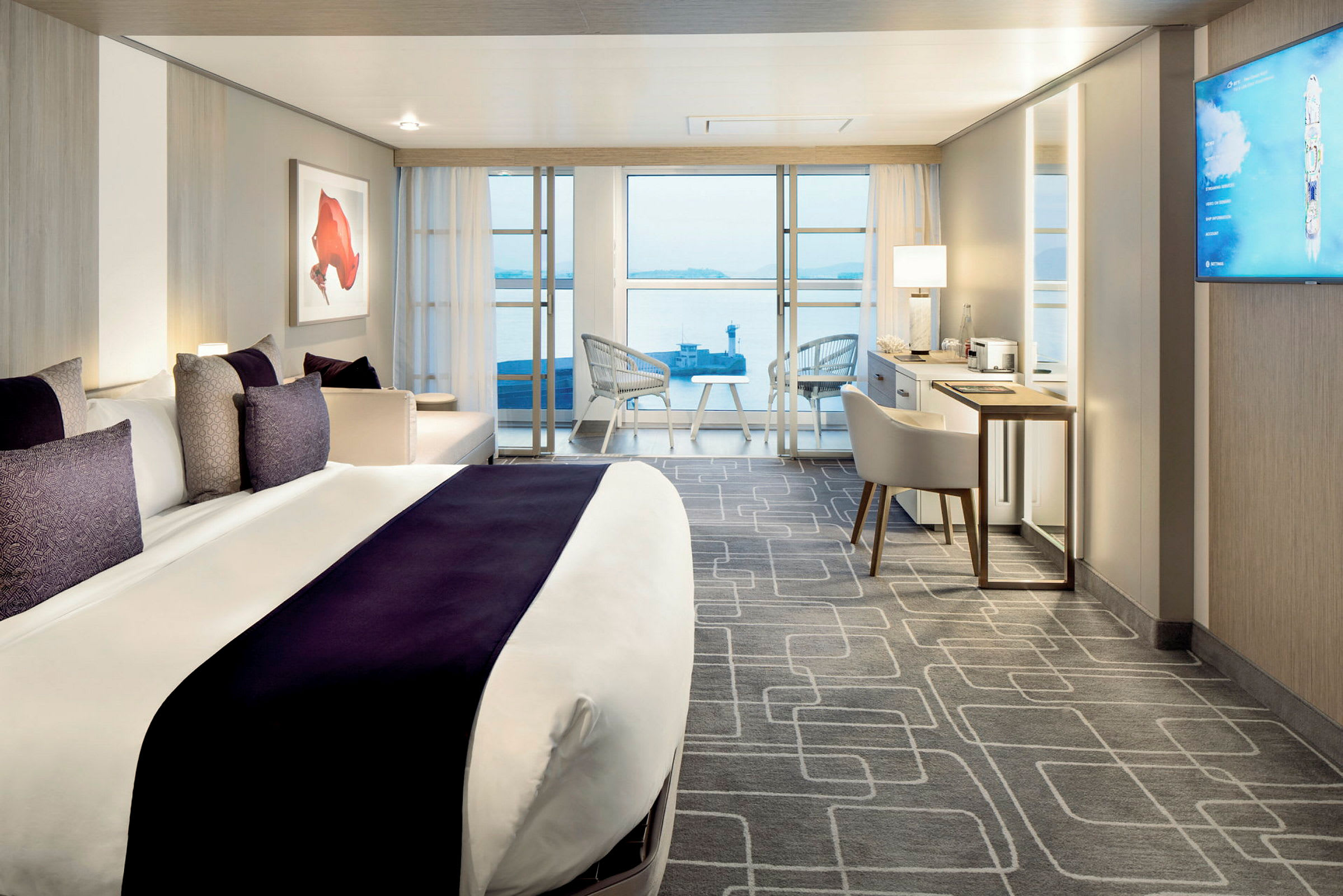 Modernt hotellrum med en stor säng, sittområde och utsikt mot havet. (AI-genererad text)