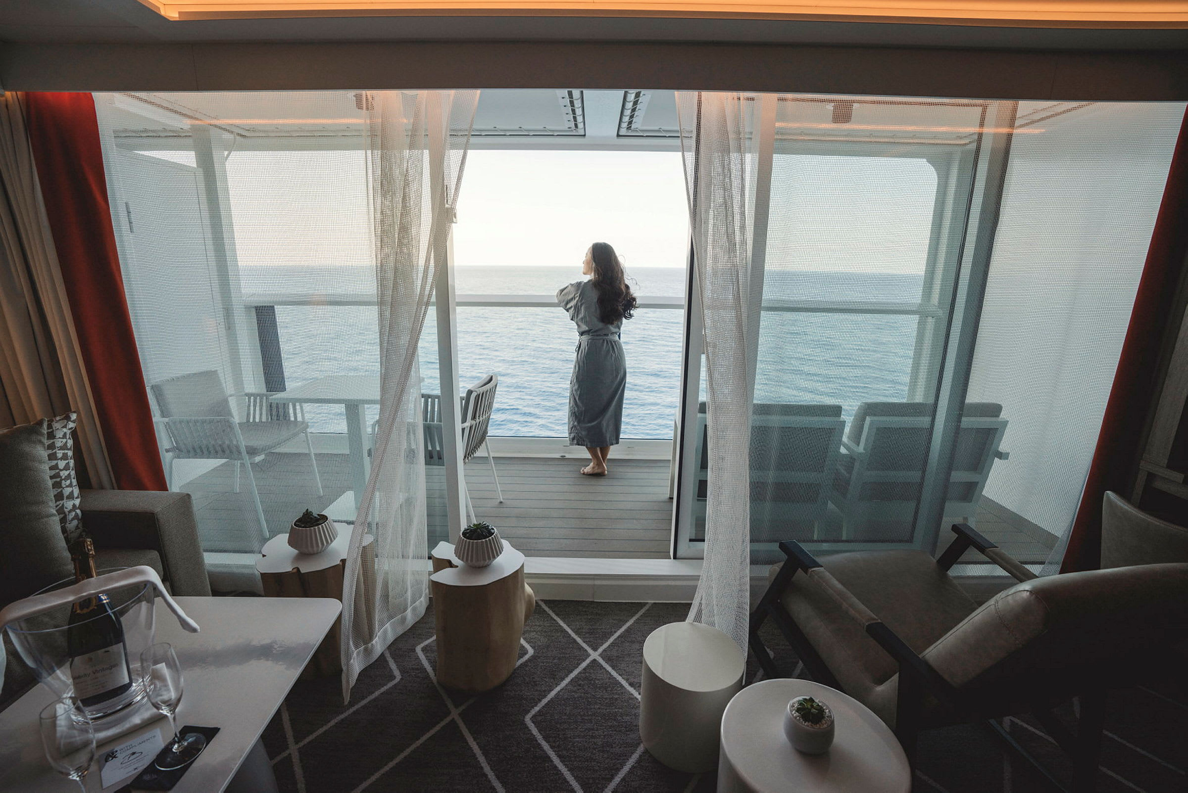 En person står på en balkong och tittar ut över havet. (AI-genererad text)