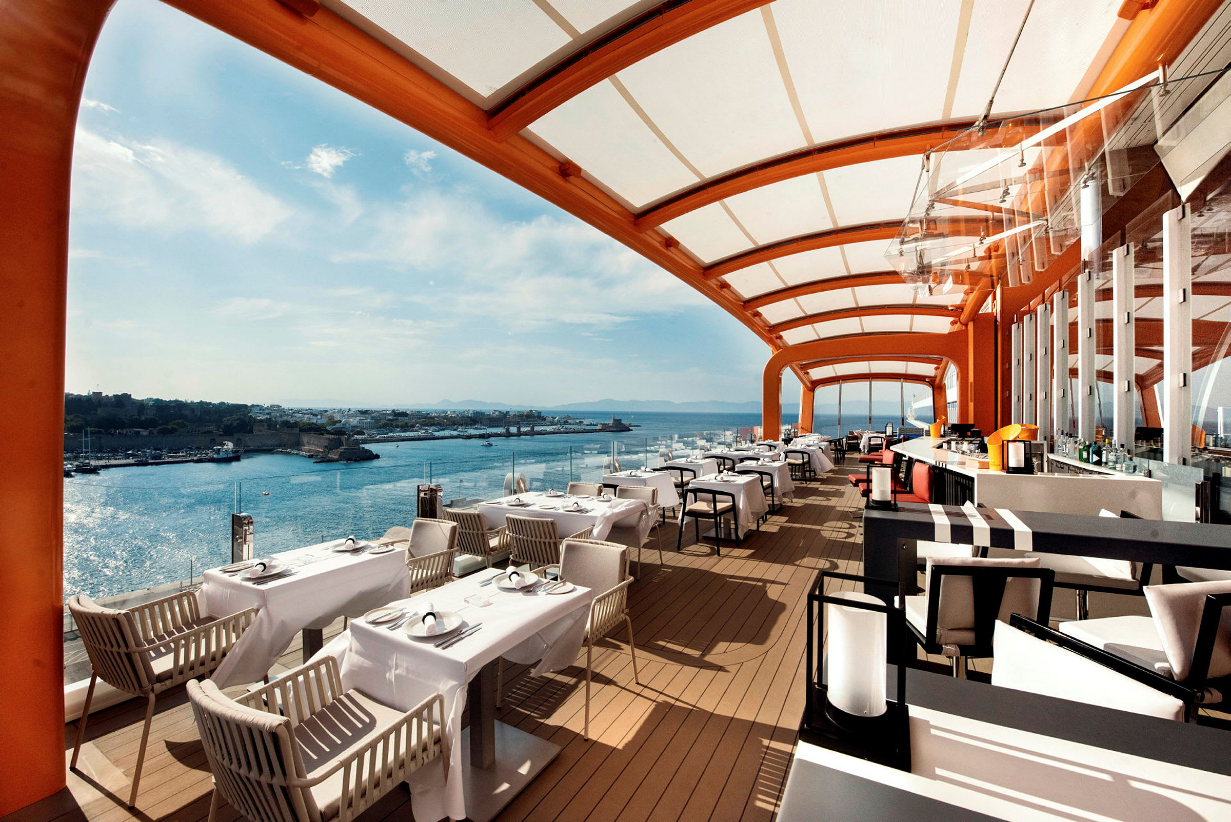Utsikt över en restaurang med täckt terrass och havet i bakgrunden. (AI-genererad text)