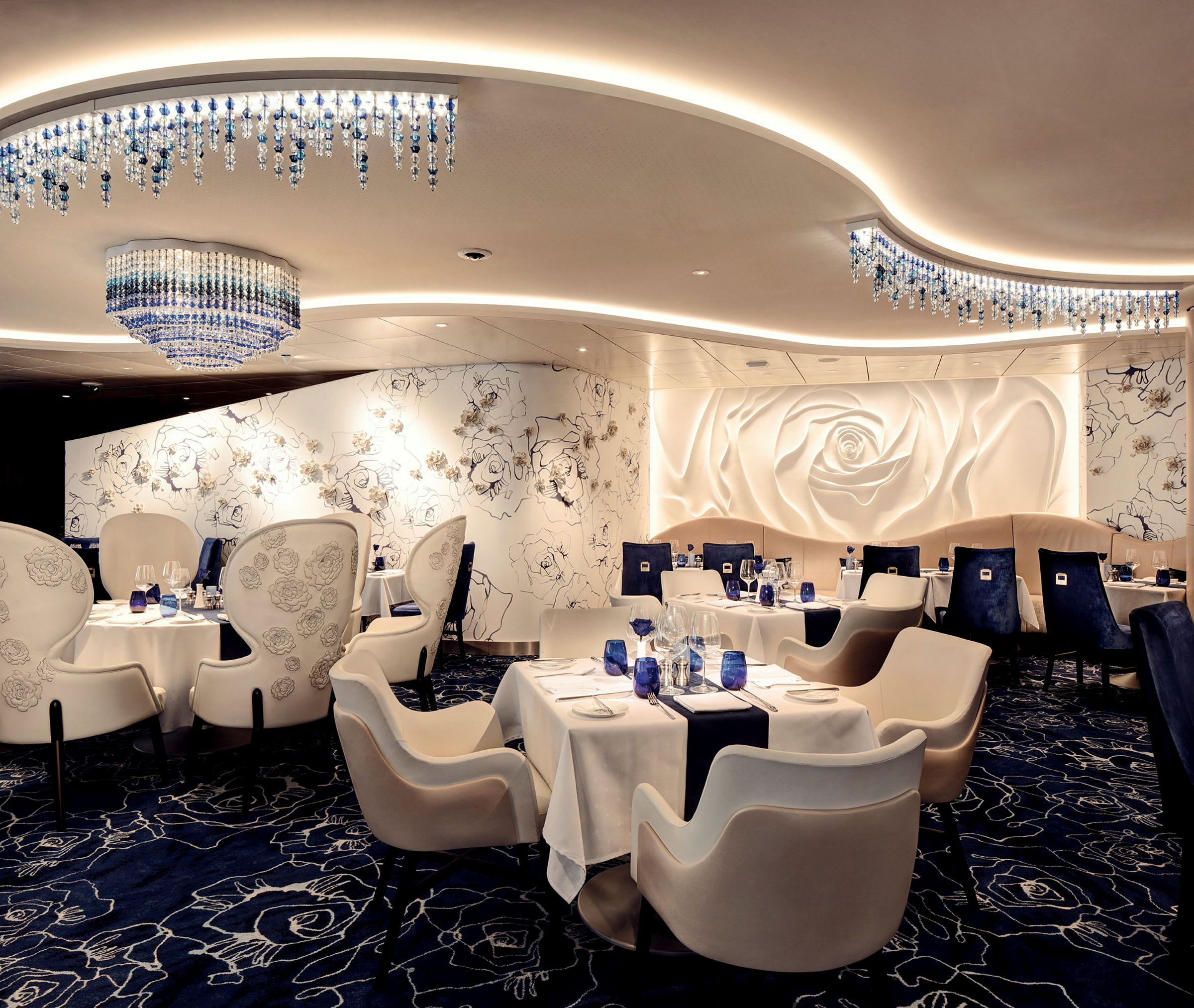 En elegant restauranginredning med vita möbler, blå detaljer och en stor väggdekoration formad som en ros. (AI-genererad text)