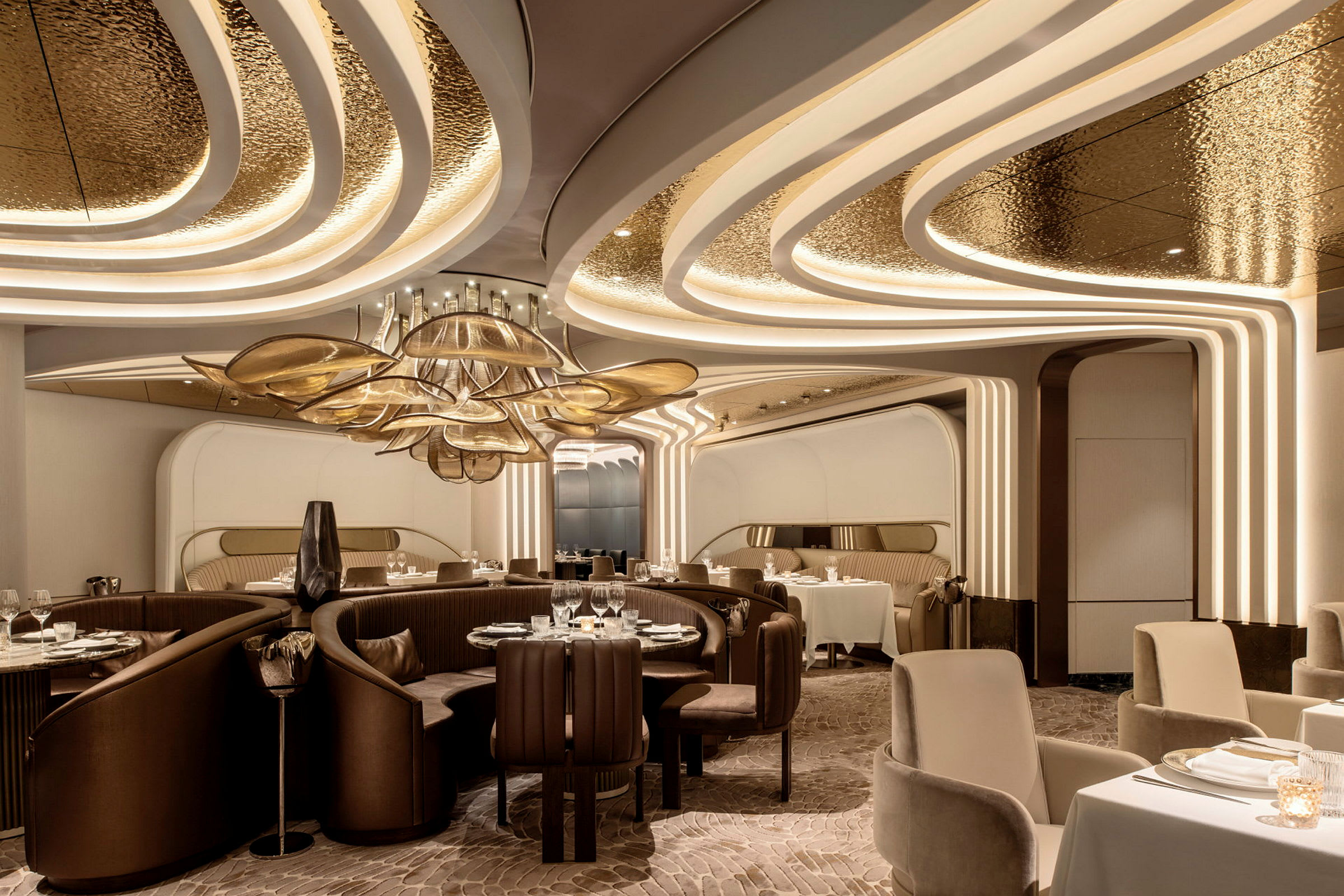 Interiör av en modern och elegant restaurang med avskilda sittplatser och dekorativa tak- och lampdetaljer. (AI-genererad text)
