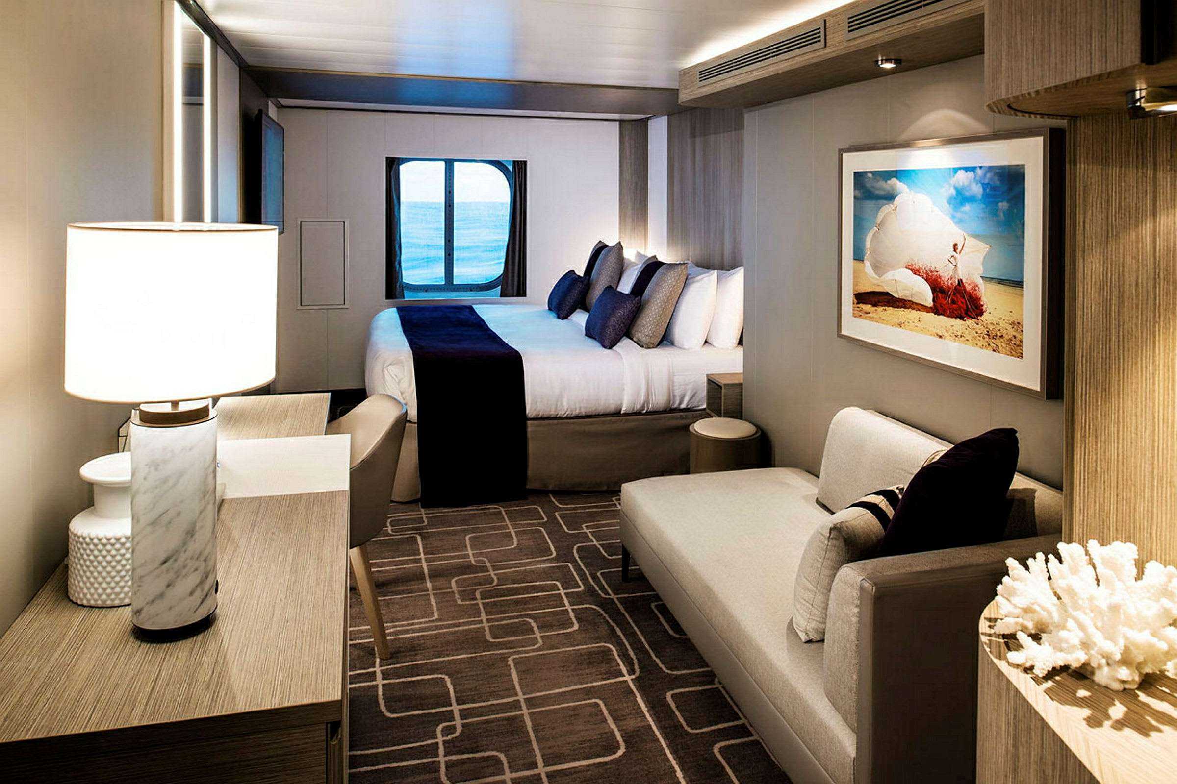 Visar ett hotellrum med en dubbelsäng, fönster med havsutsikt och modern inredning. (AI-genererad text)
