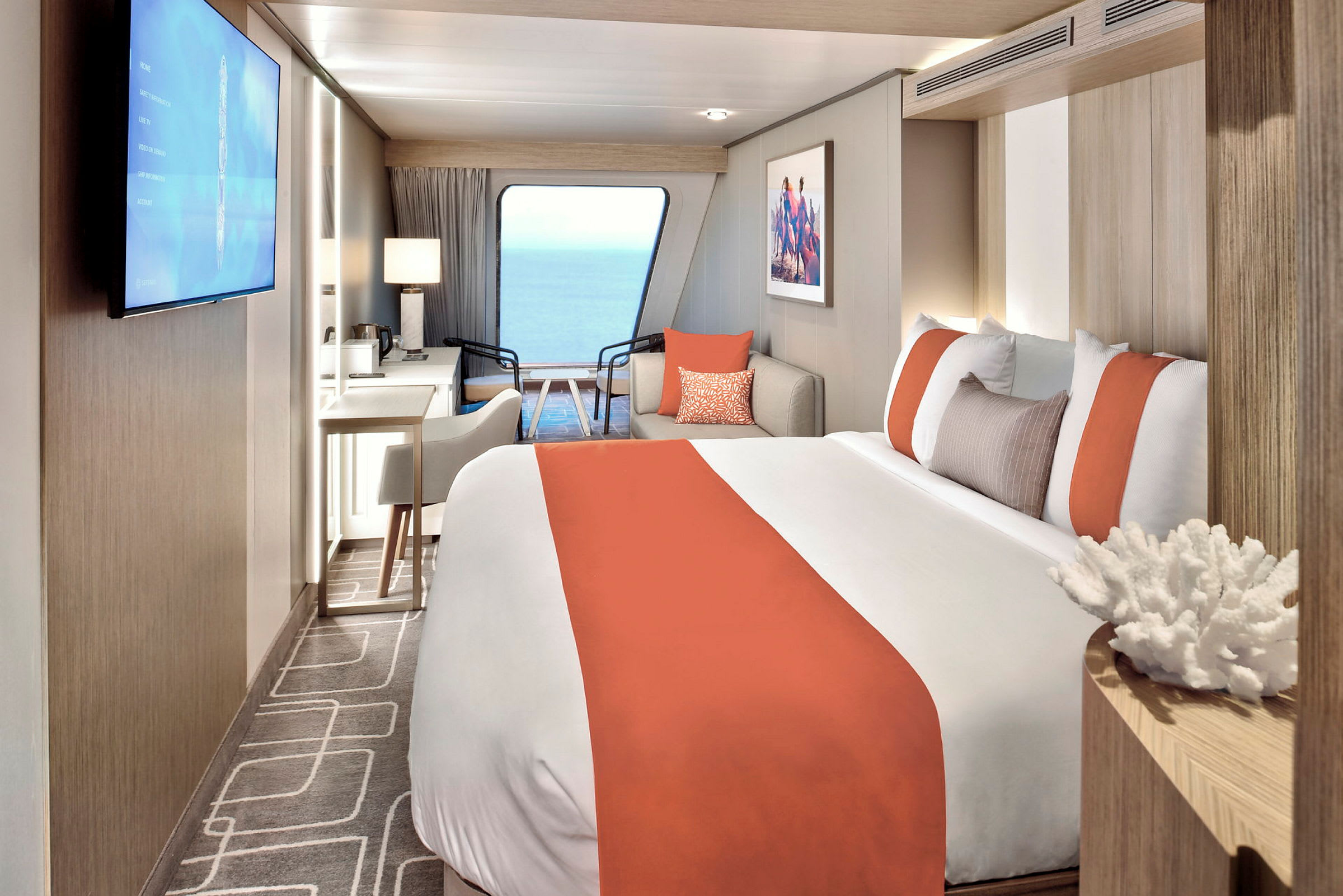 En modern hotellrum med säng, skrivbord och fönsterutsikt mot havet. (AI-genererad text)