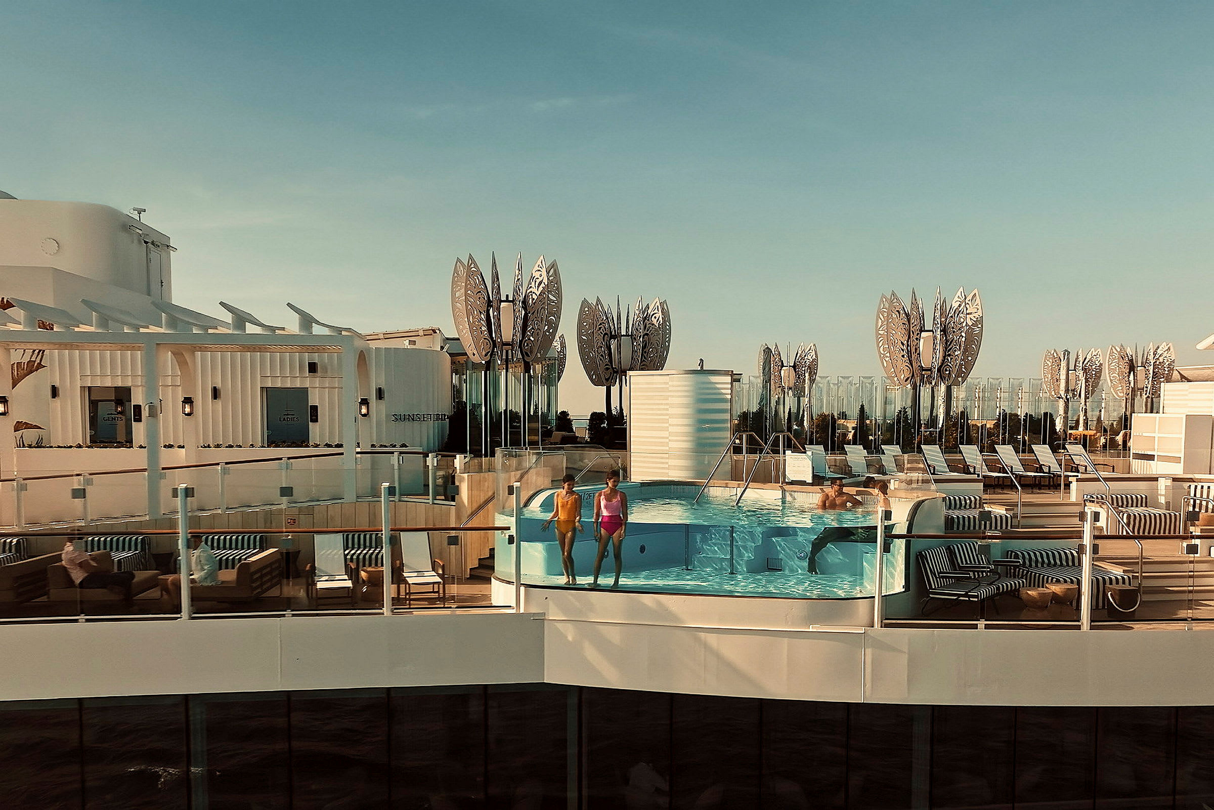 Två personer står vid kanten av en pool ombord på ett fartyg. (AI-genererad text)