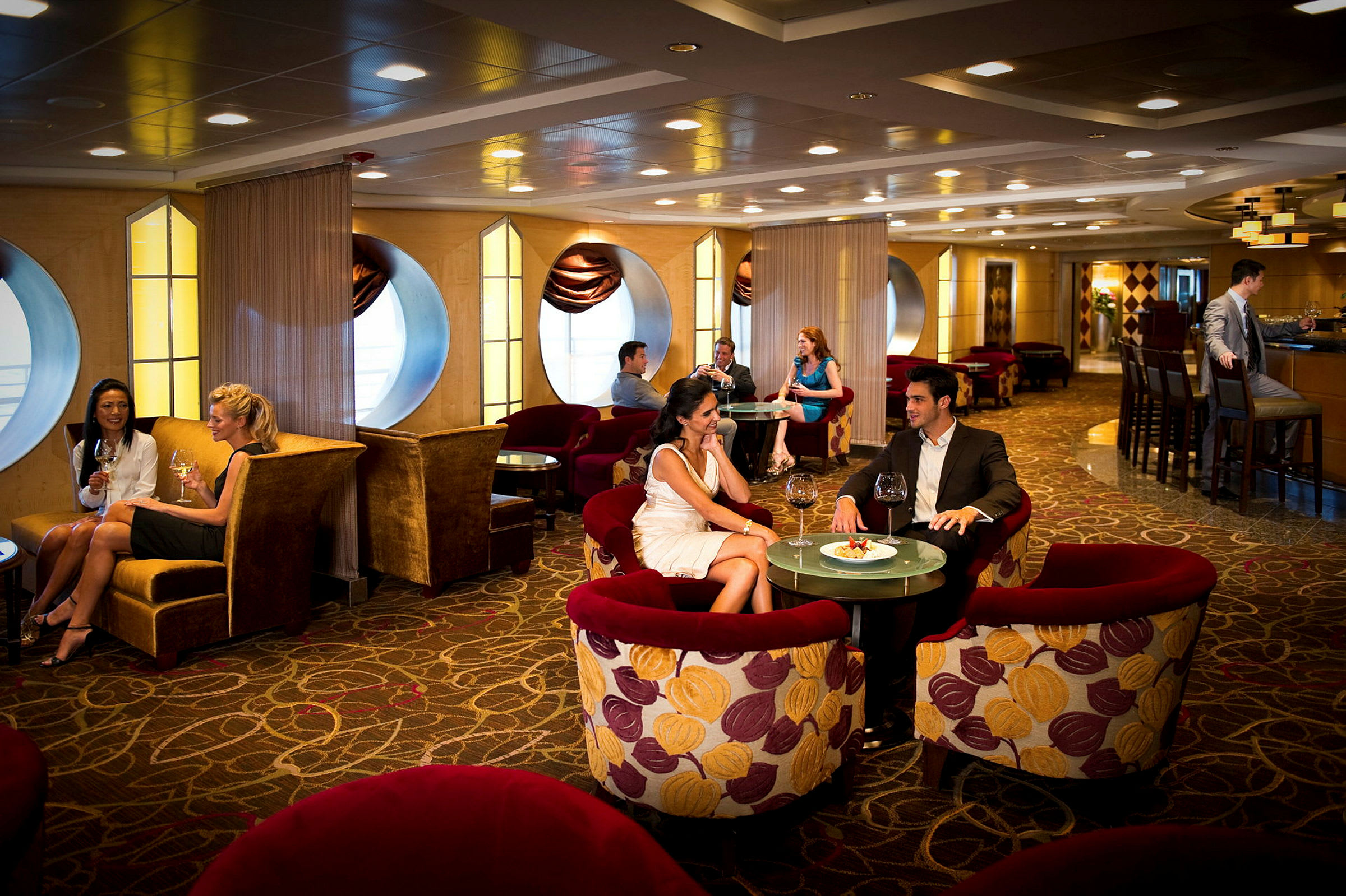 En elegant lounge med personer sittande vid bord och njutande av mat och dryck. (AI-genererad text)
