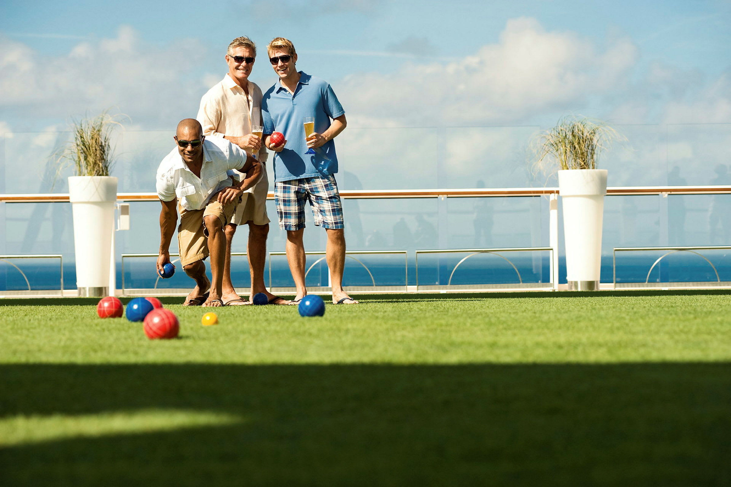 Personer spelar boccia på gräs med havet i bakgrunden. (AI-genererad text)