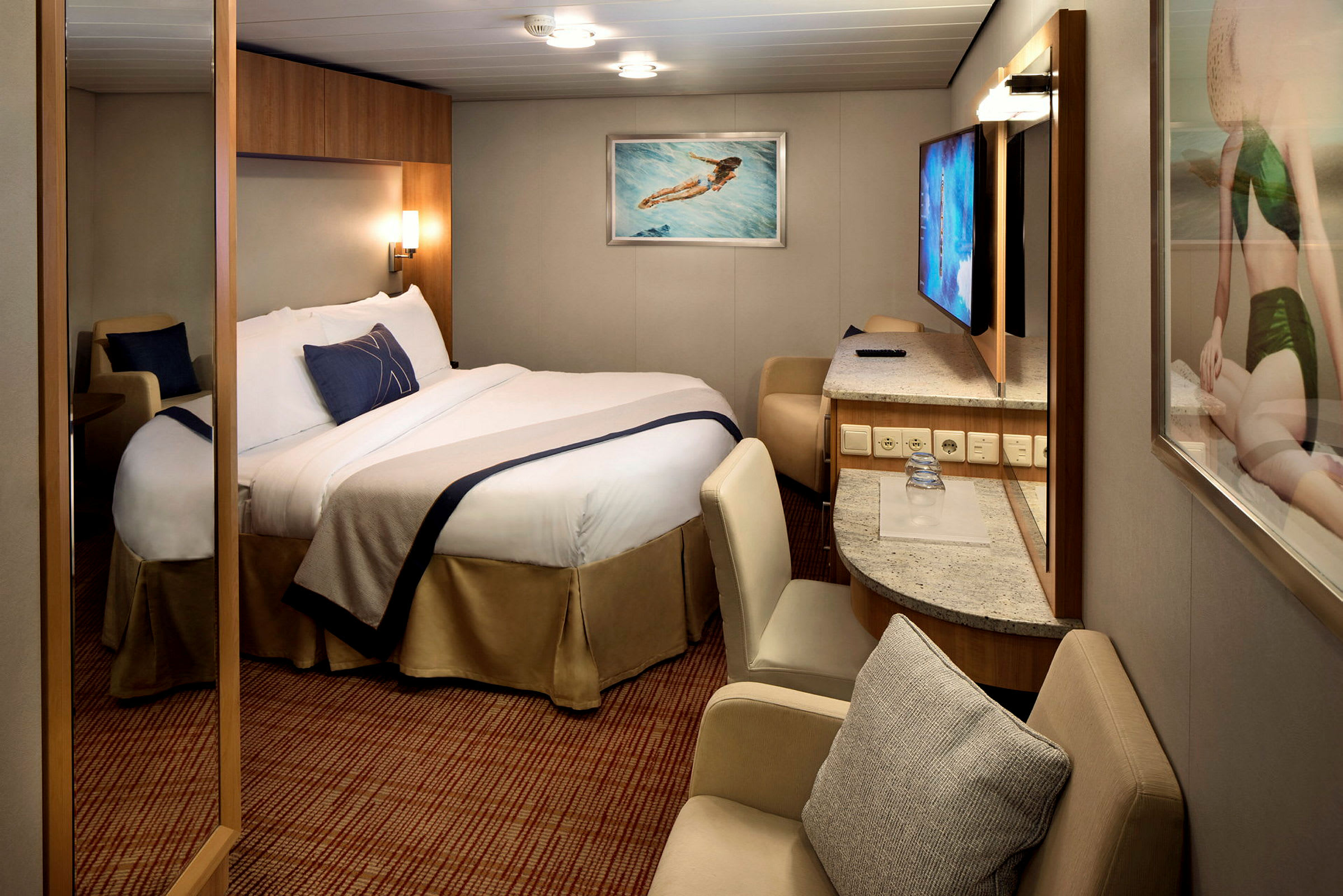 Ett hotellrum med en dubbelsäng, skrivbord och sittmöbler. (AI-genererad text)