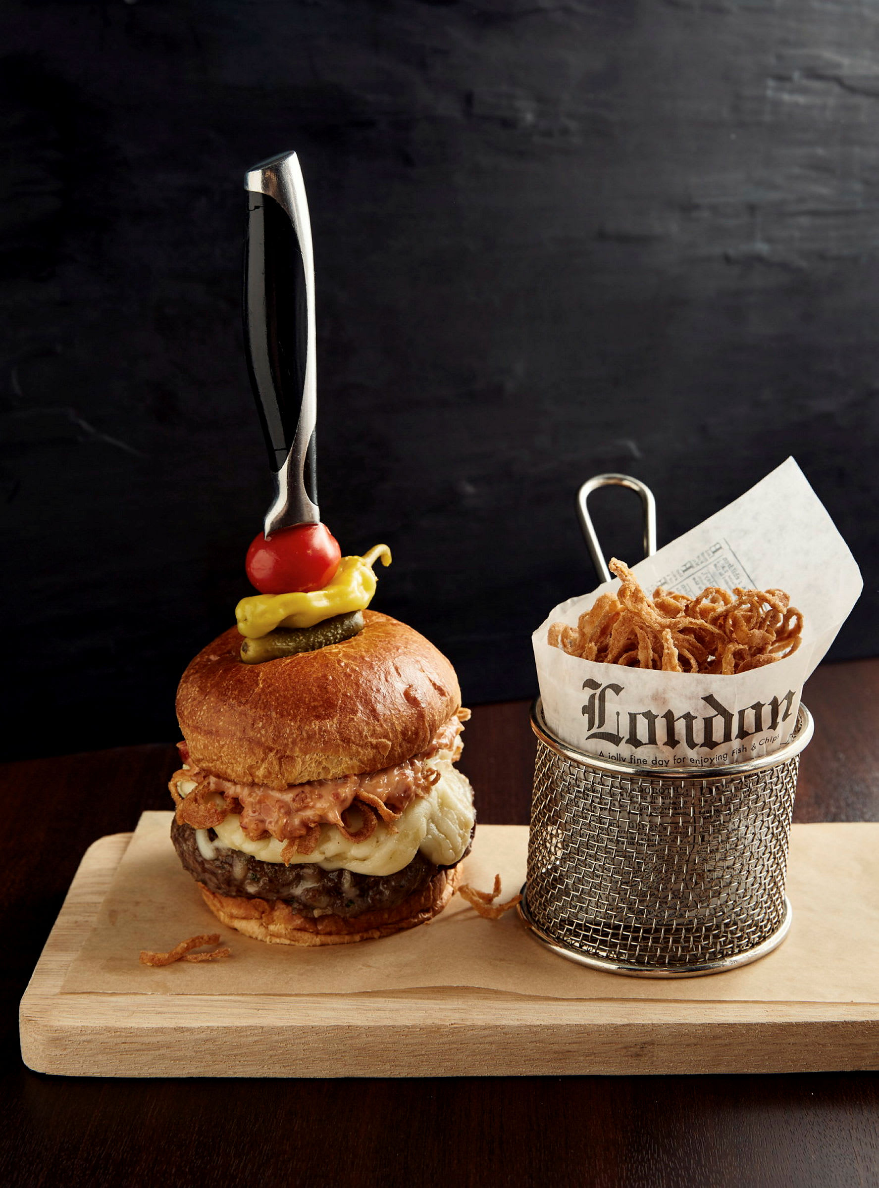 En hamburgare serverad med lökringar bredvid. (AI-genererad text)