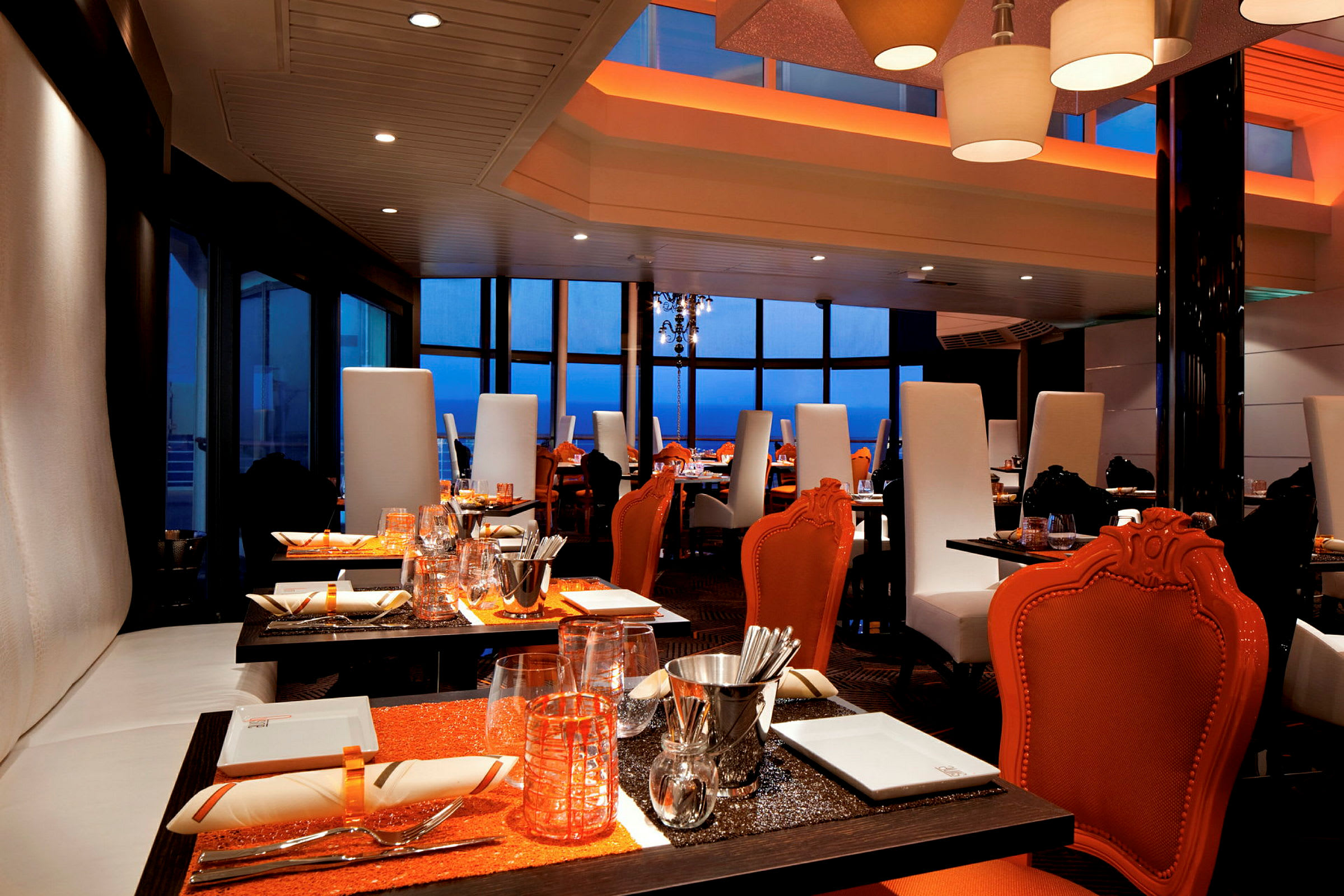 En restaurang med eleganta orange och vita möbler och dukade bord. (AI-genererad text)