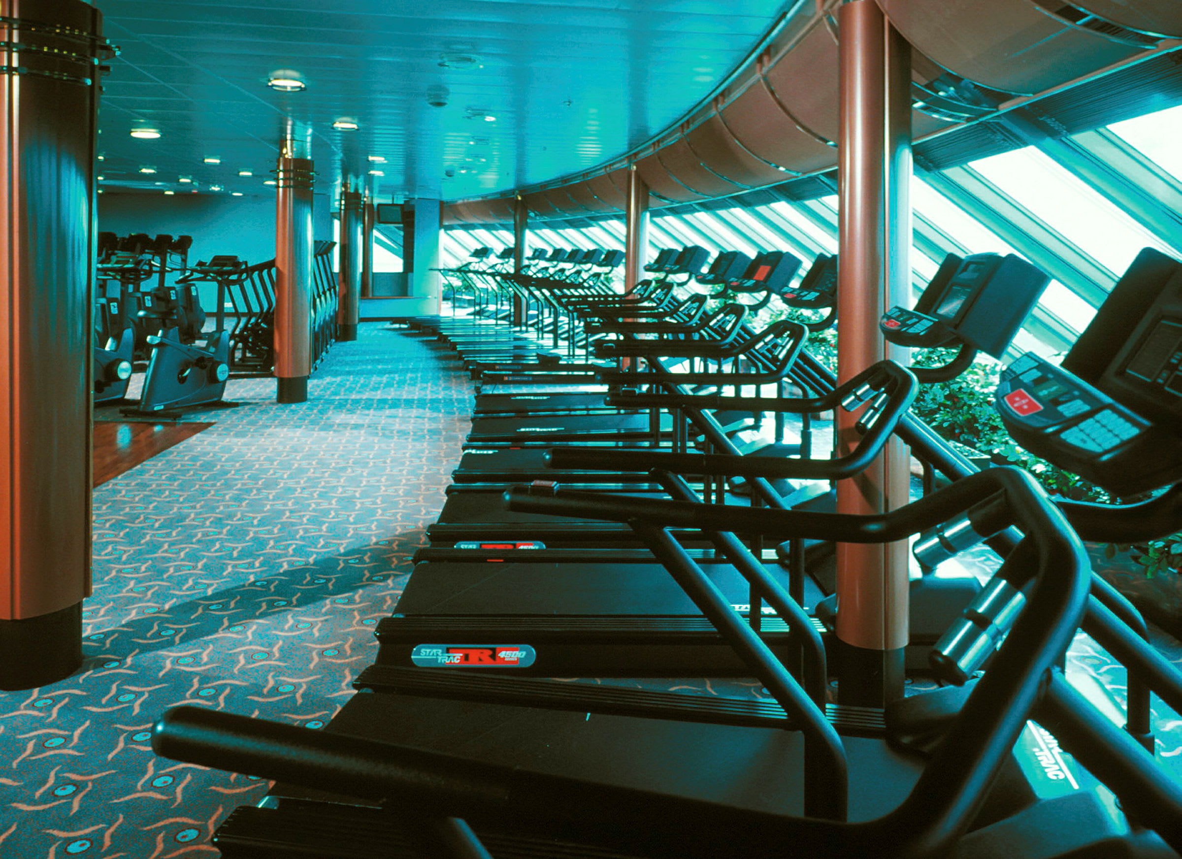 Ett gym med flera löpband och träningsutrustning. (AI-genererad text)