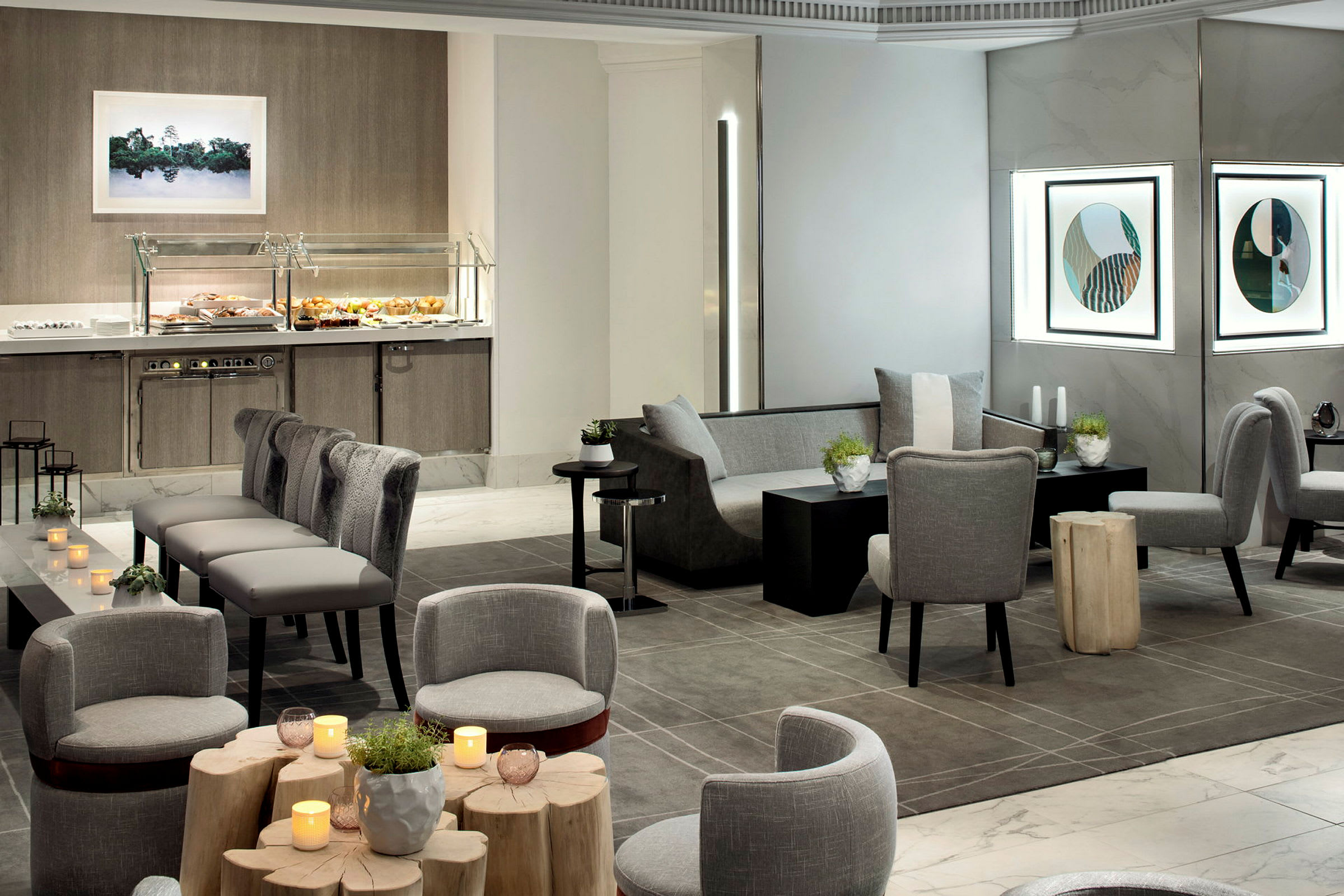 Ett modernt hotellrum med sittplatser, bord, dekorationer och en buffésektion. (AI-genererad text)