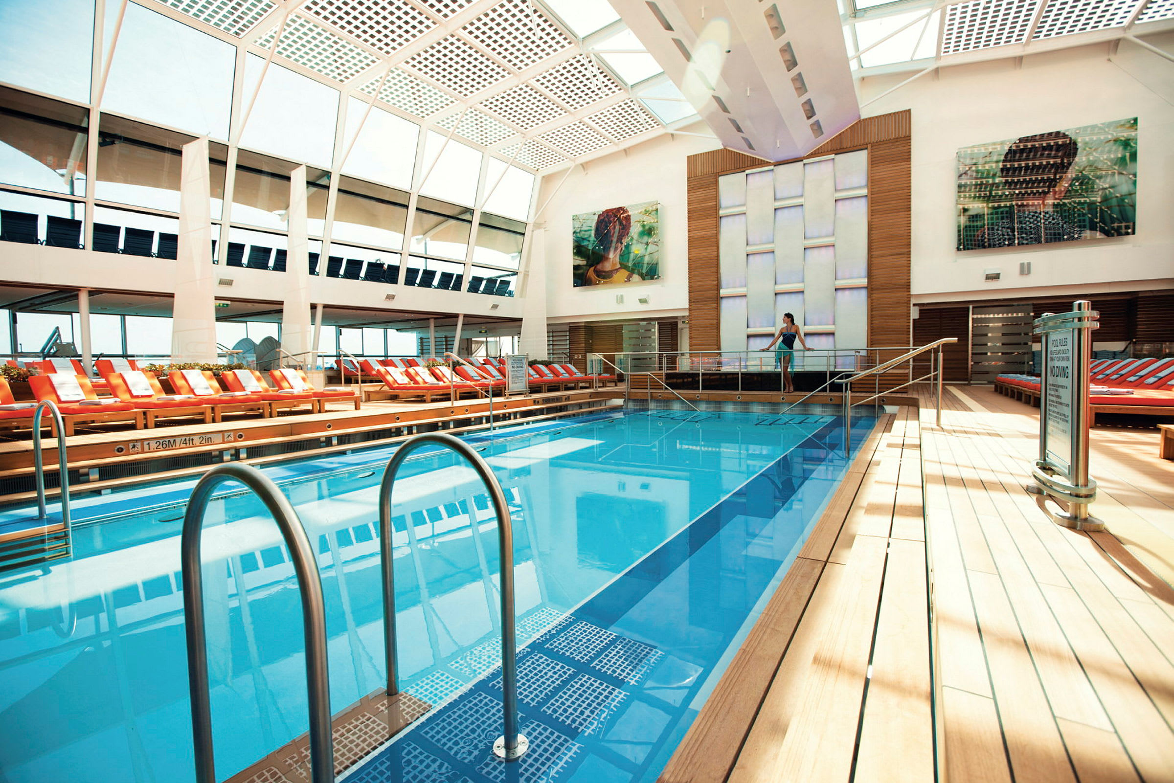 Inomhuspool med solstolar och glastak. (AI-genererad text)