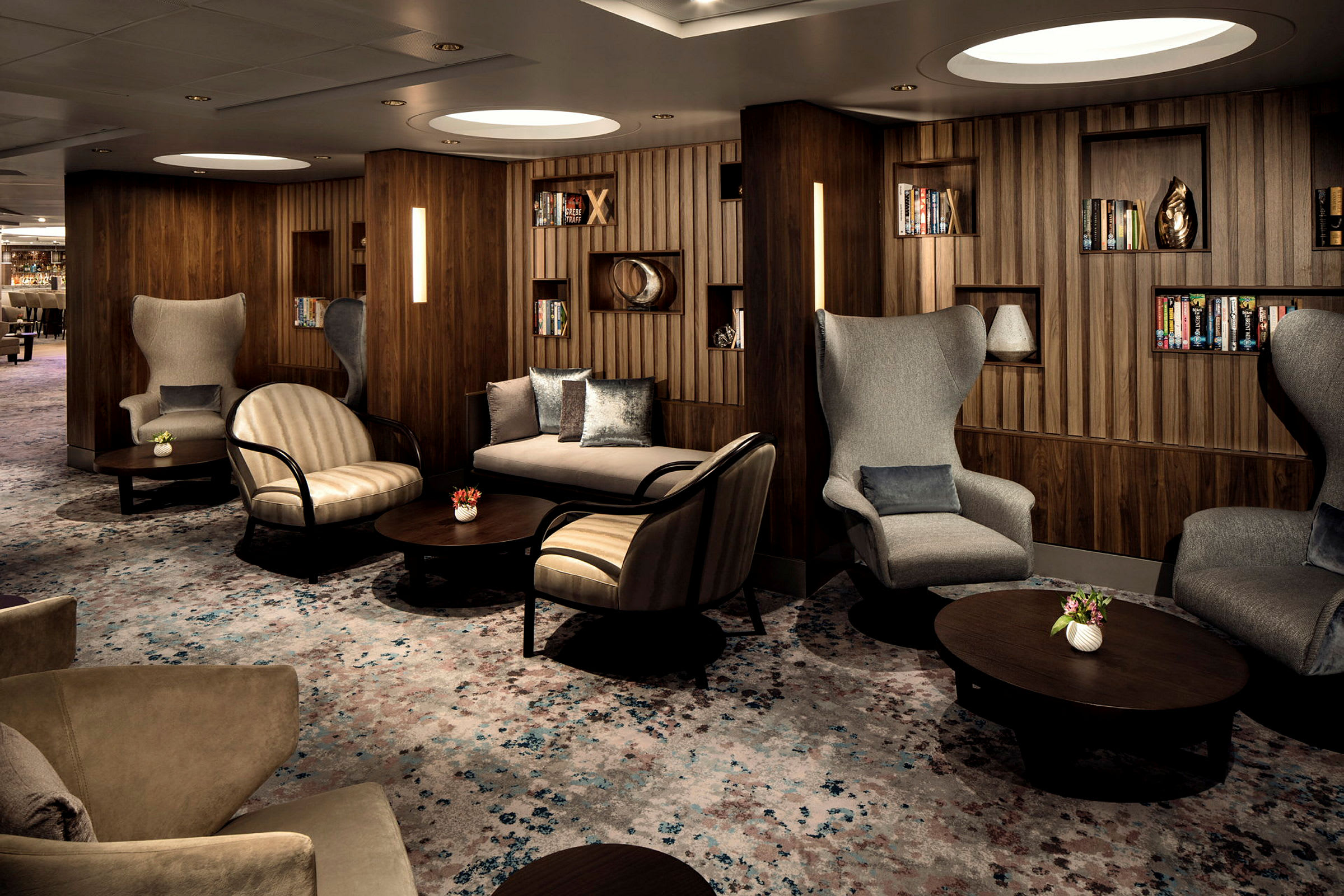 En elegant lounge med sittgrupper och bokhyllor. (AI-genererad text)