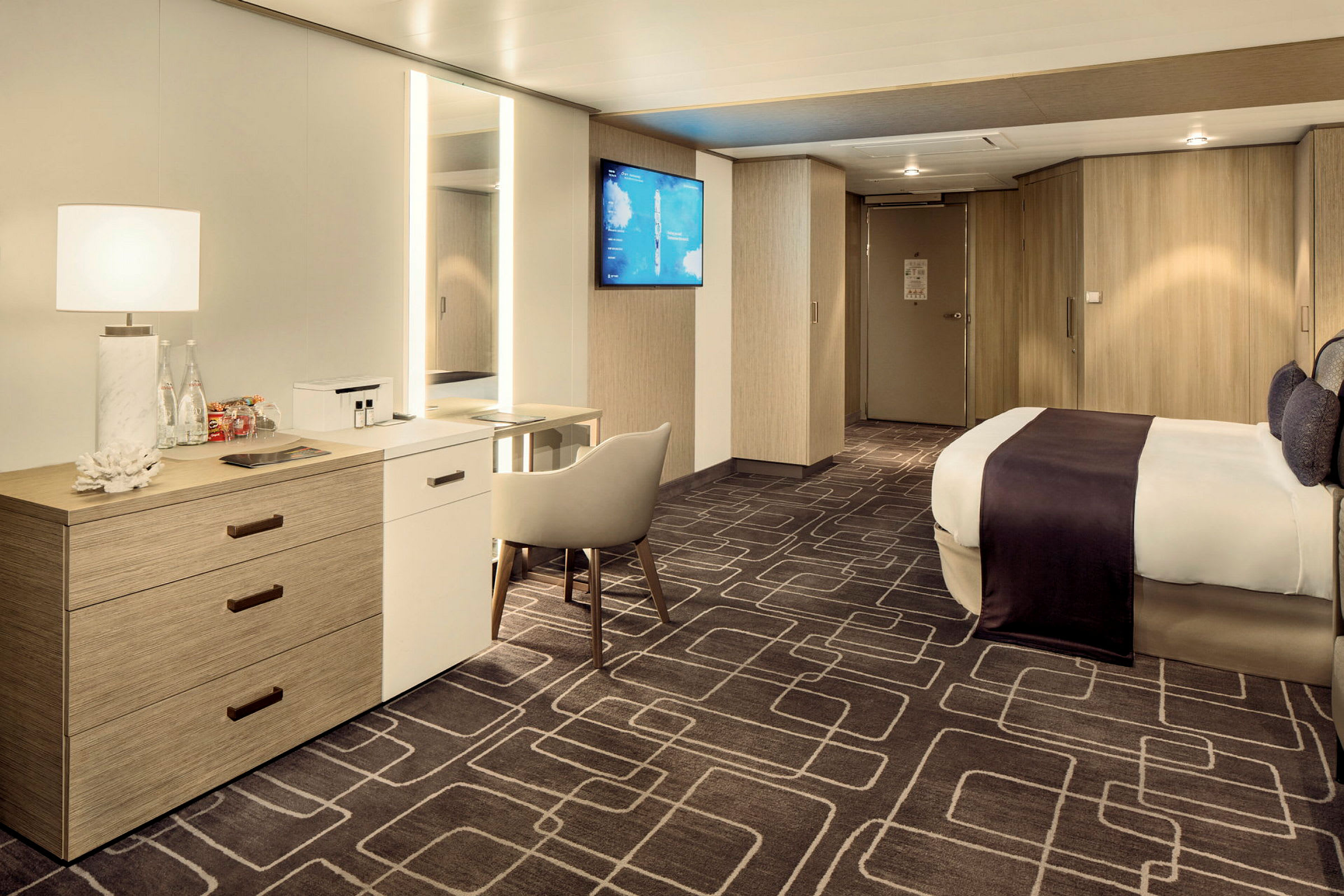 Ett modernt och rymligt hotellrum med en stor säng, skrivbord, stol och garderober. (AI-genererad text)