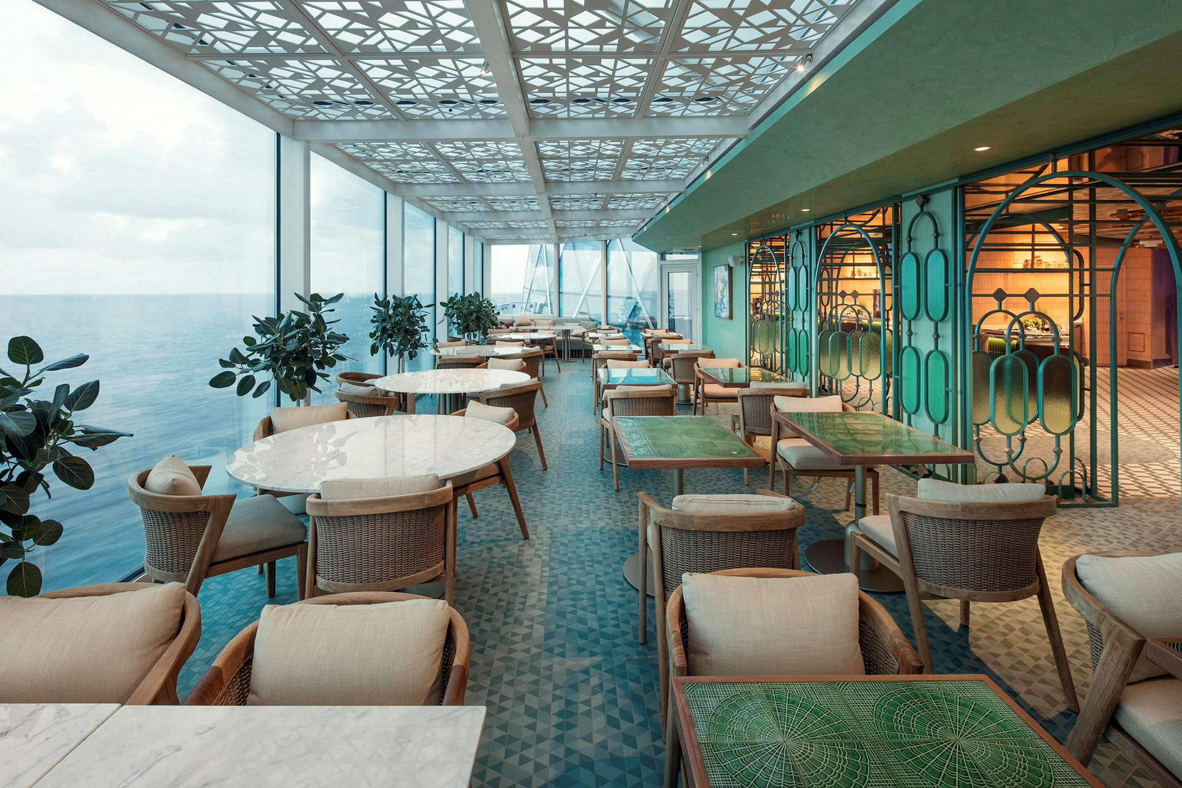 En restaurang med havsutsikt, moderna möbler och ljusa färger. (AI-genererad text)