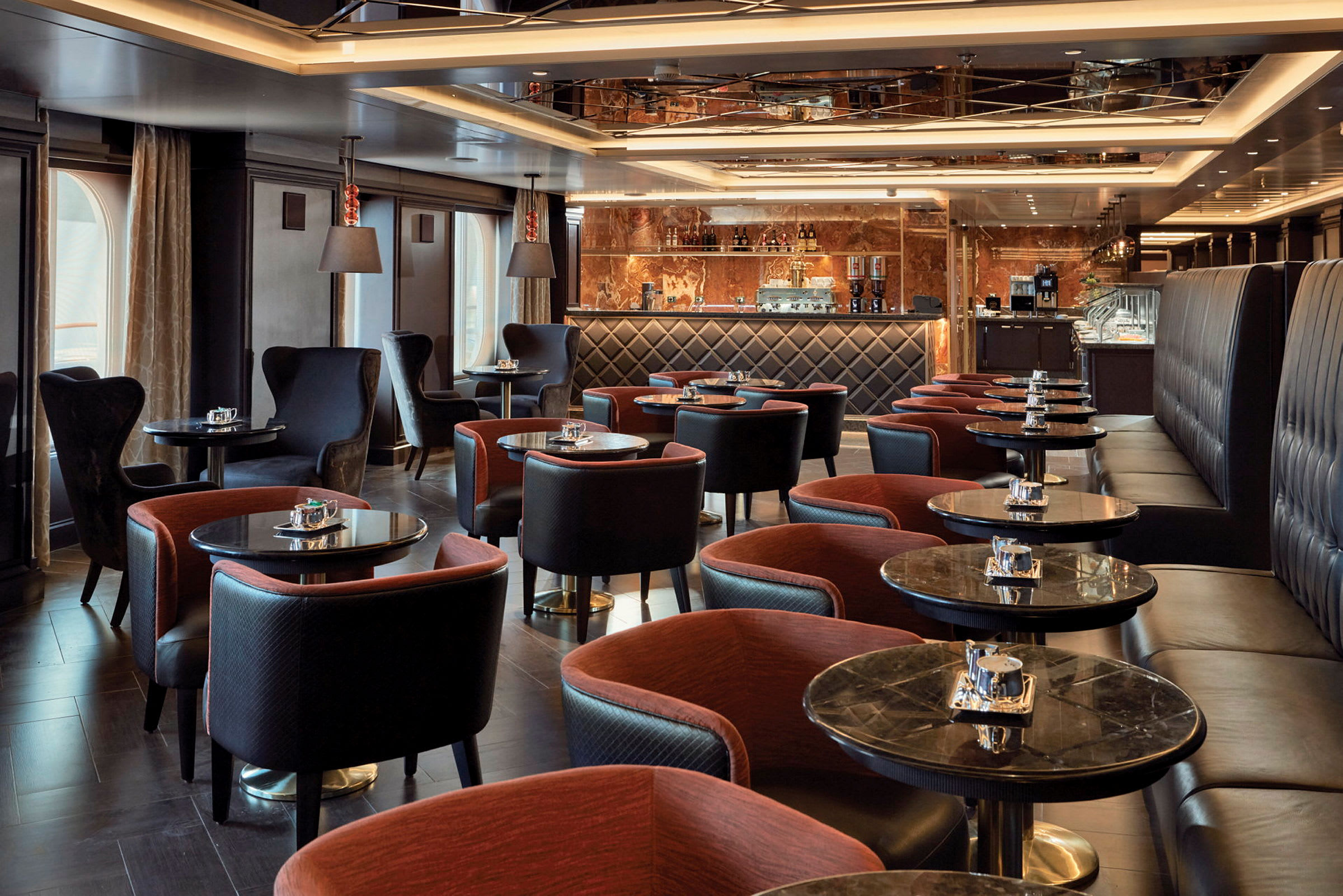 En elegant lounge med bord, fåtöljer och en bardisk i bakgrunden. (AI-genererad text)