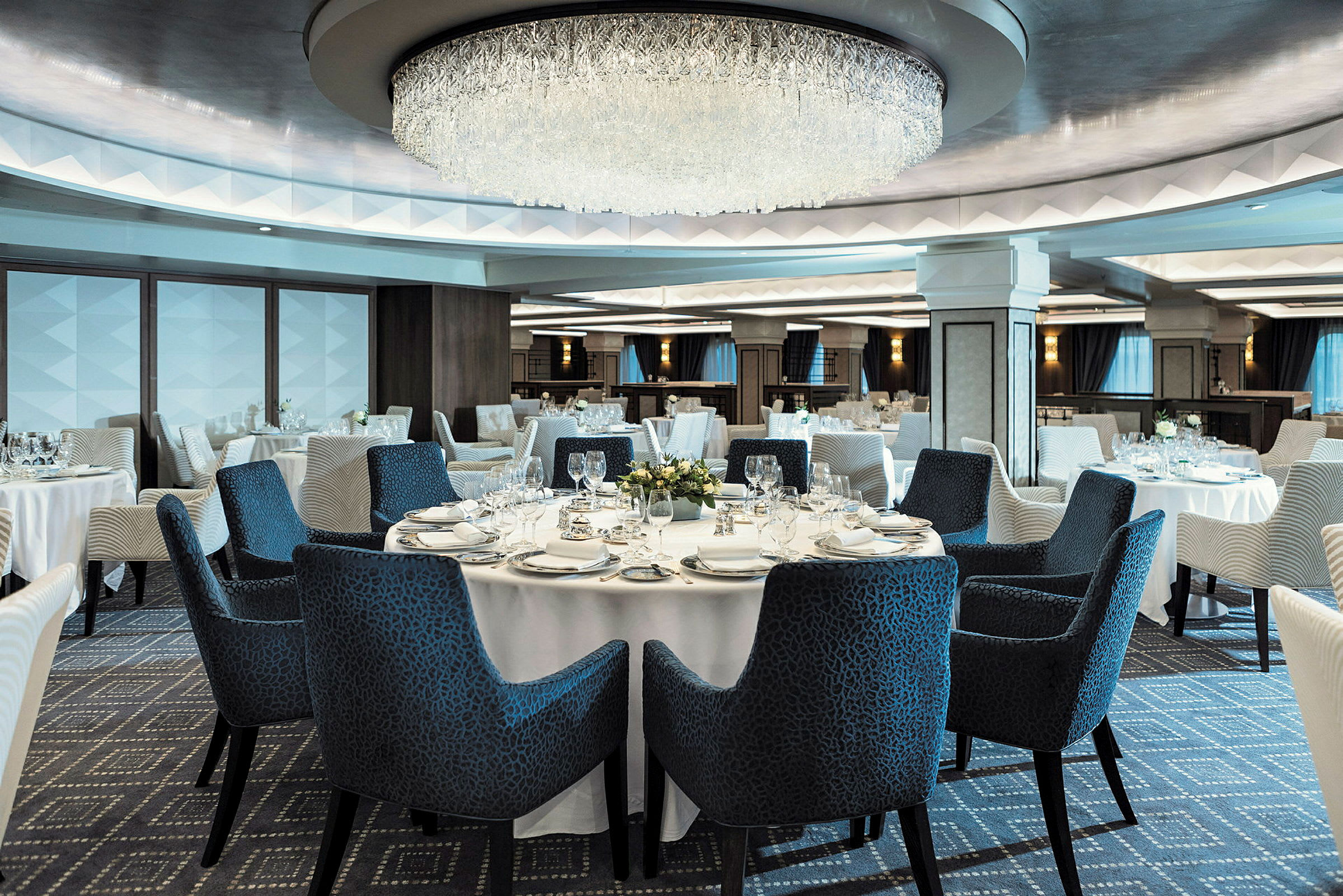 En elegant restaurang med dukade bord och en imponerande ljuskrona. (AI-genererad text)