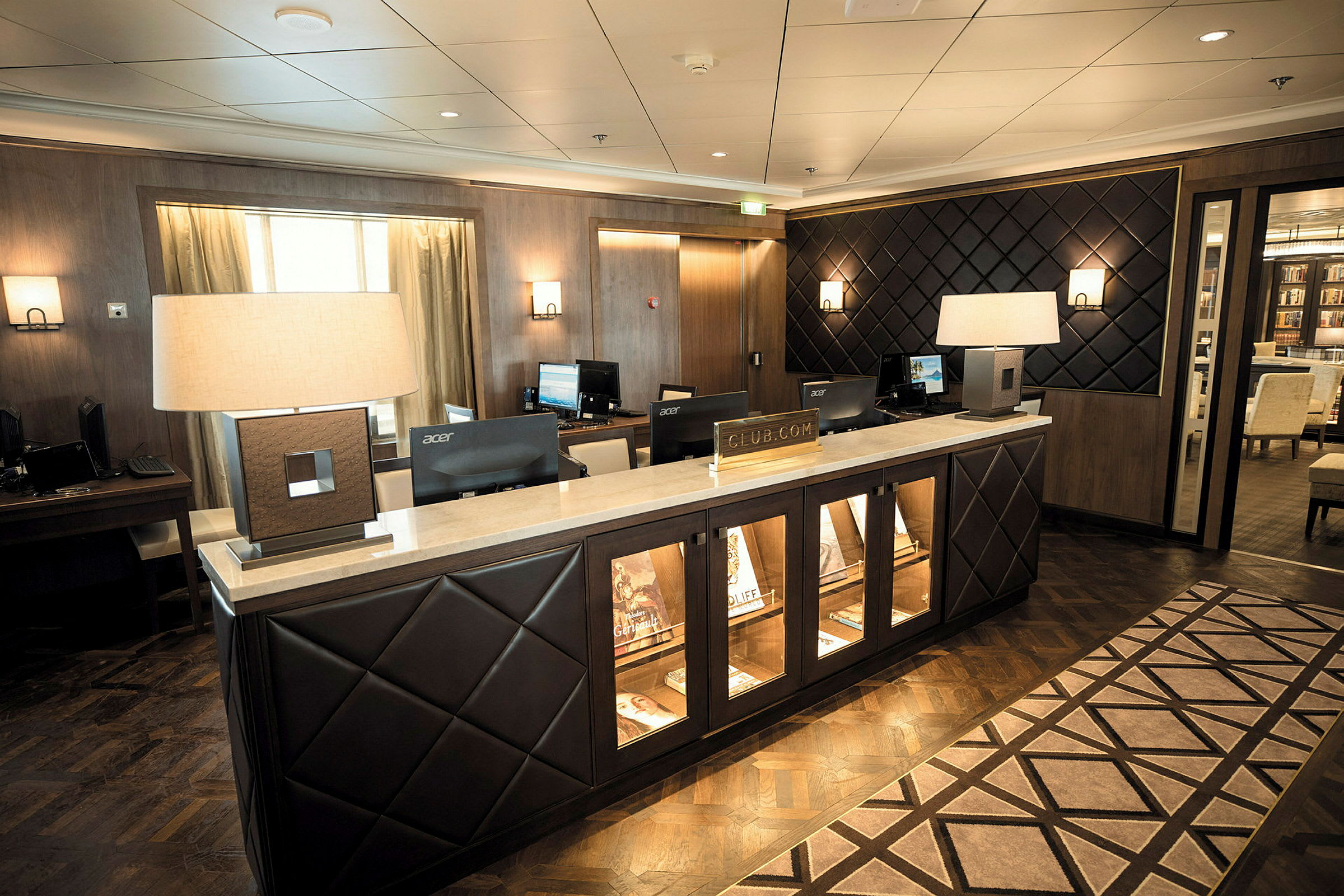 En receptionsdisk i ett hotell med datorer och lampor. (AI-genererad text)