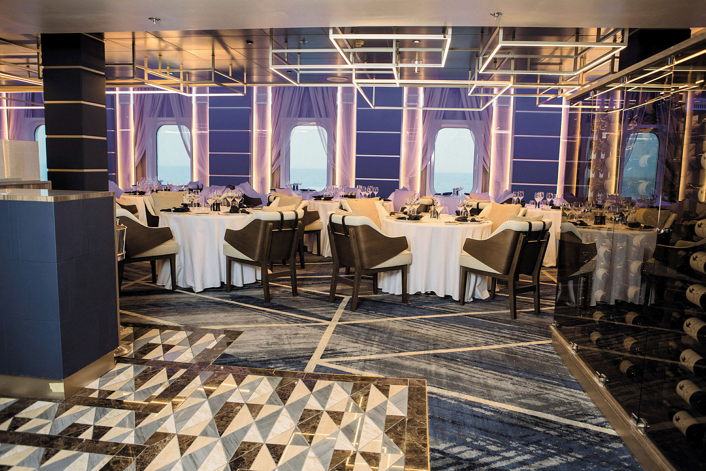 En restaurang med dukade bord och stolar samt stora fönster. (AI-genererad text)