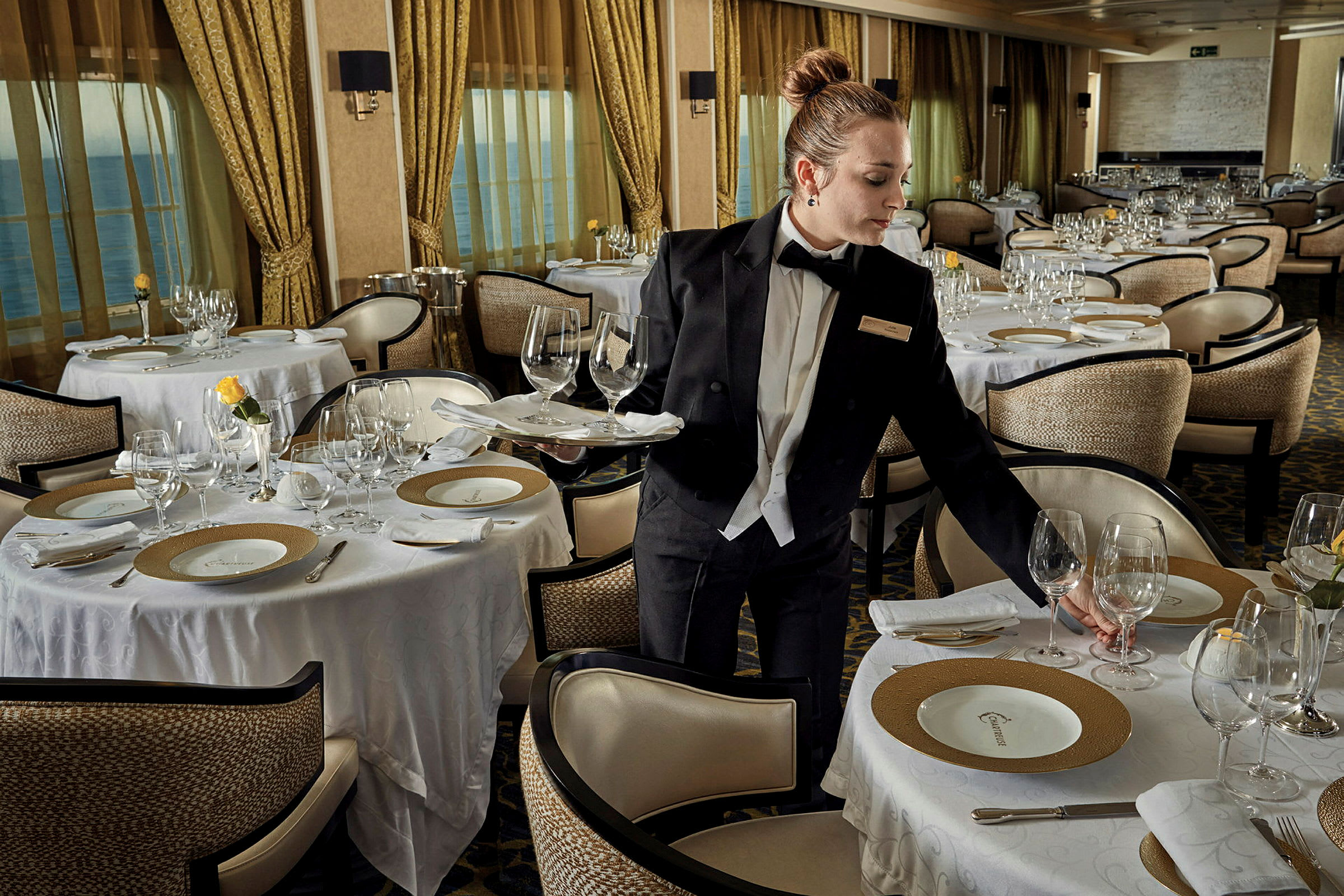 En elegant restaurang med dukade bord och en servitör i uniform. (AI-genererad text)