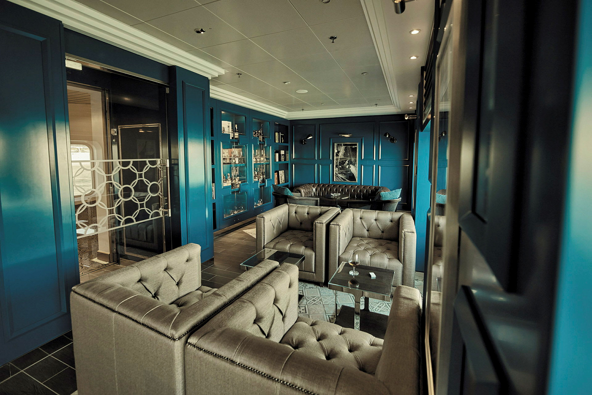 En elegant loungemiljö med blå väggar, fåtöljer och soffor. (AI-genererad text)