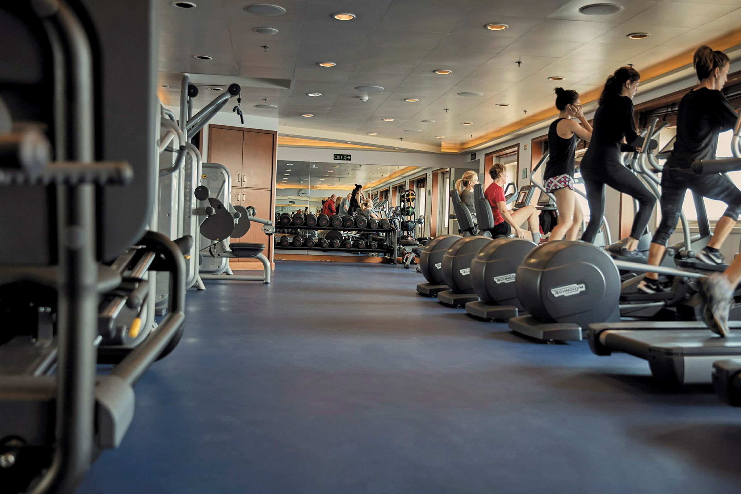 Gym med träningsmaskiner och människor som tränar. (AI-genererad text)