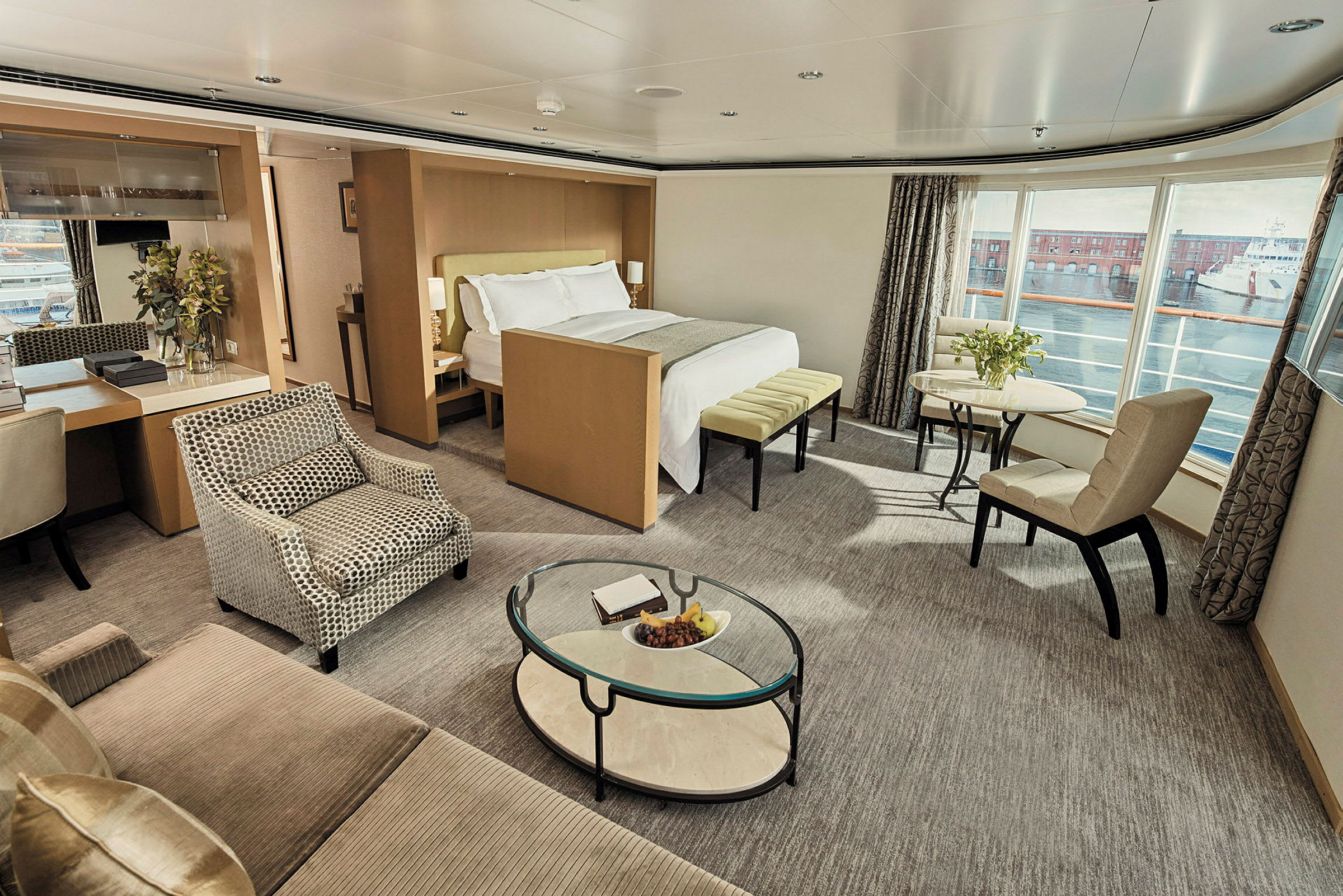 Lyxigt hotellrum med säng, sittgrupp och stort fönster med utsikt. (AI-genererad text)