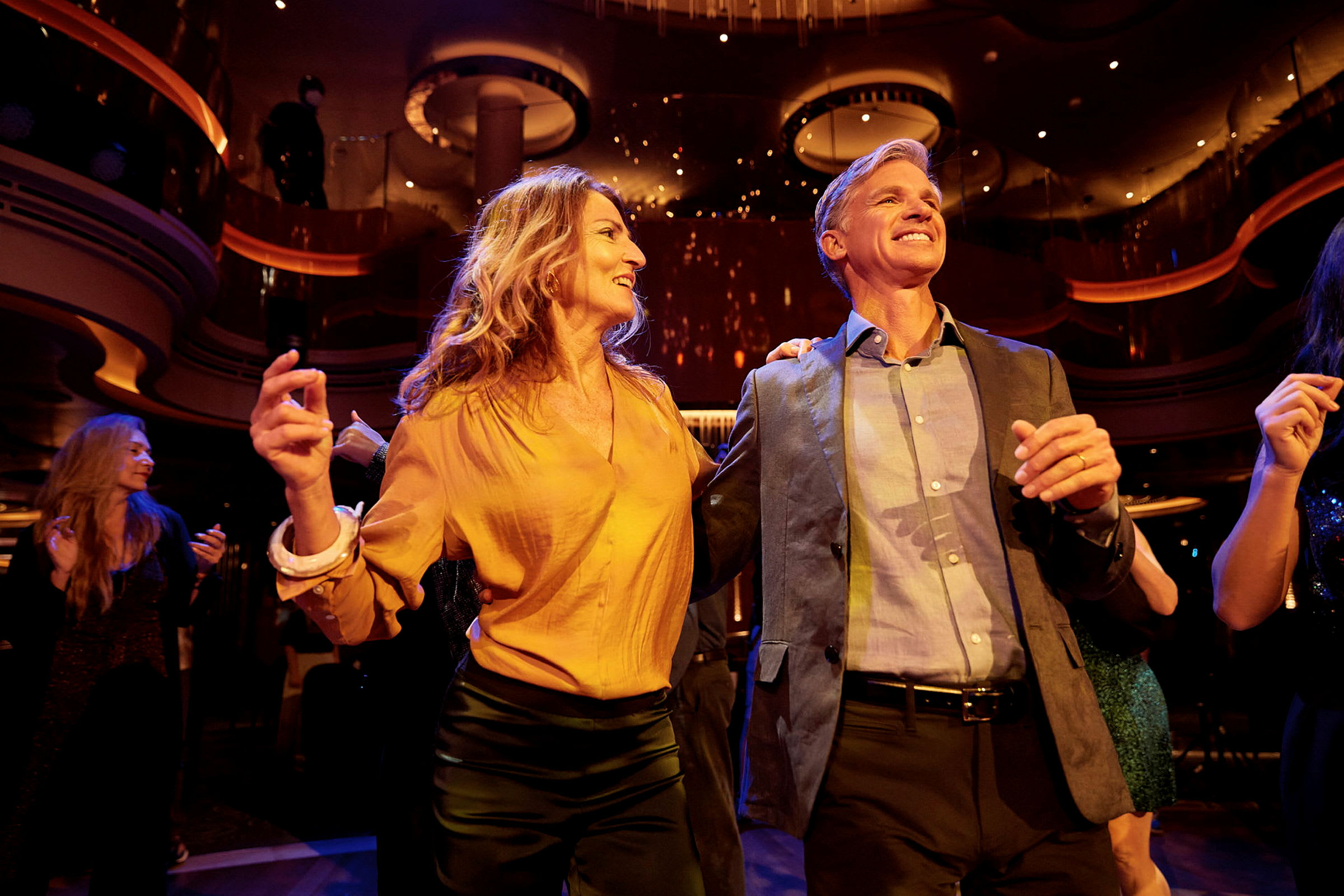 Personer dansar på en fest, omgivna av elegant interiör och festbelysning. (AI-genererad text)