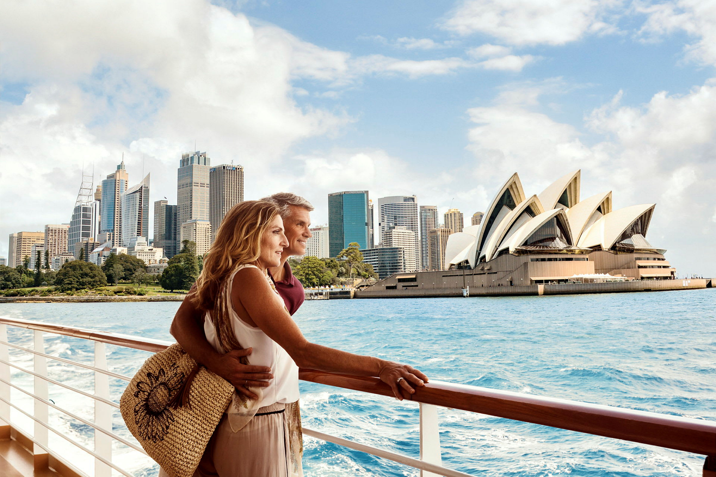 Två personer står vid ett räcke ombord på en båt med utsikt mot Sydney Opera House och stadens skyline. (AI-genererad text)