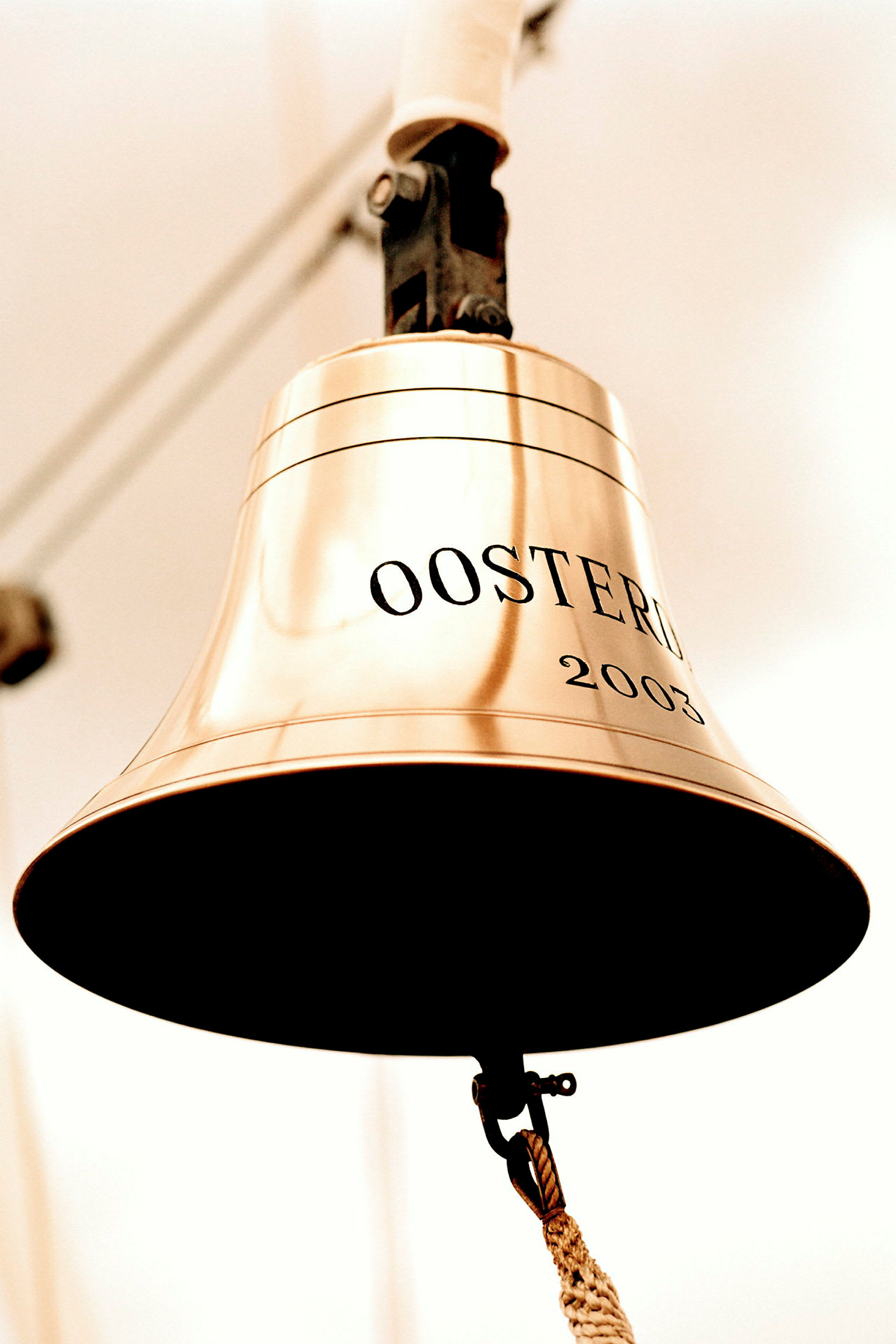 Närbild på en guldfärgad klocka med texten 'Ooster...' och årtalet '2003'. (AI-genererad text)