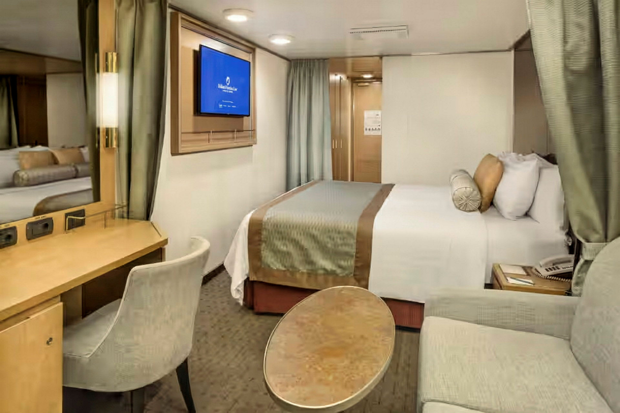 Ett modernt hotellrum med en dubbelsäng, TV, arbetsplats och sittgrupp. (AI-genererad text)