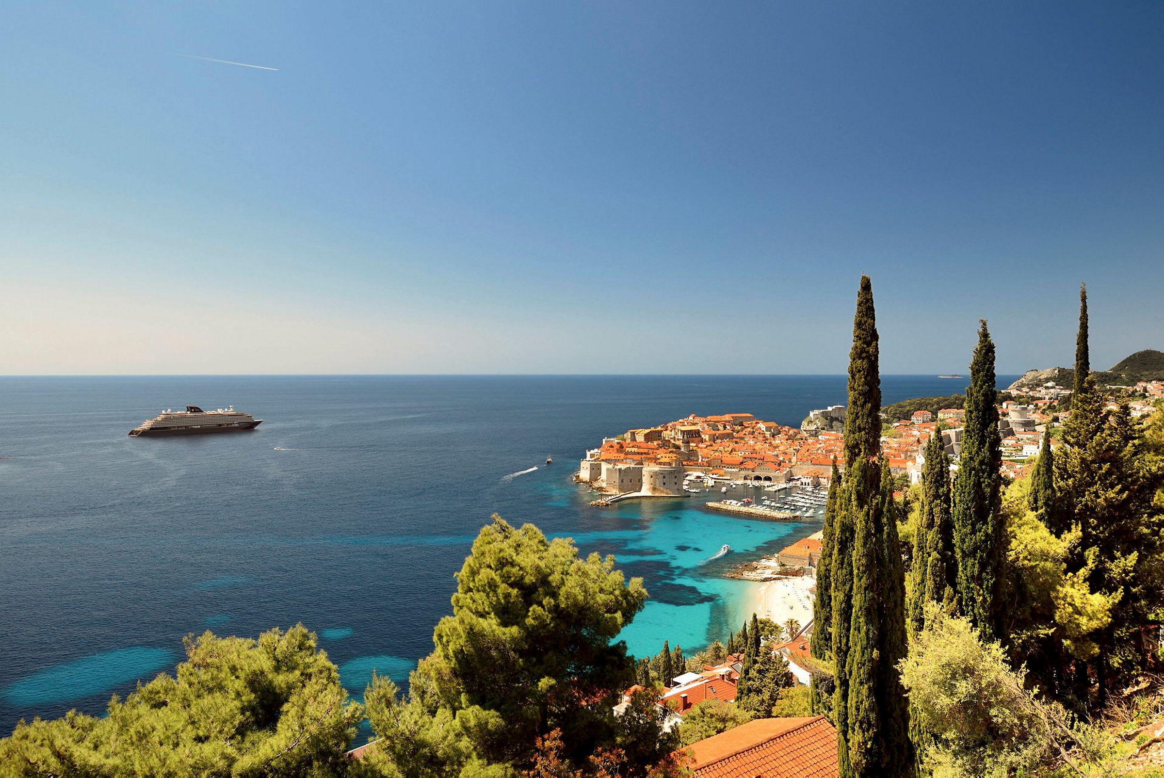 Vy över Dubrovniks gamla stad med hav och kryssningsfartyg i bakgrunden. (AI-genererad text)