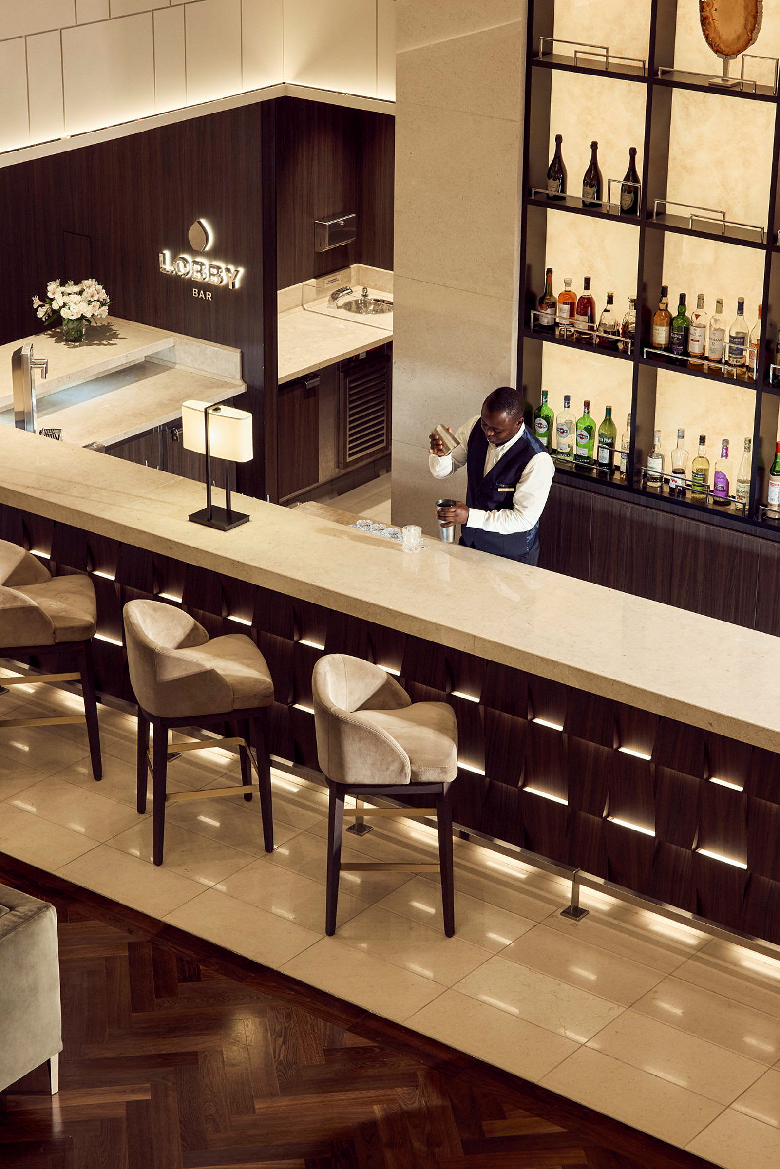 En elegant hotellbar med fyra barstolar och ljus belysning. (AI-genererad text)