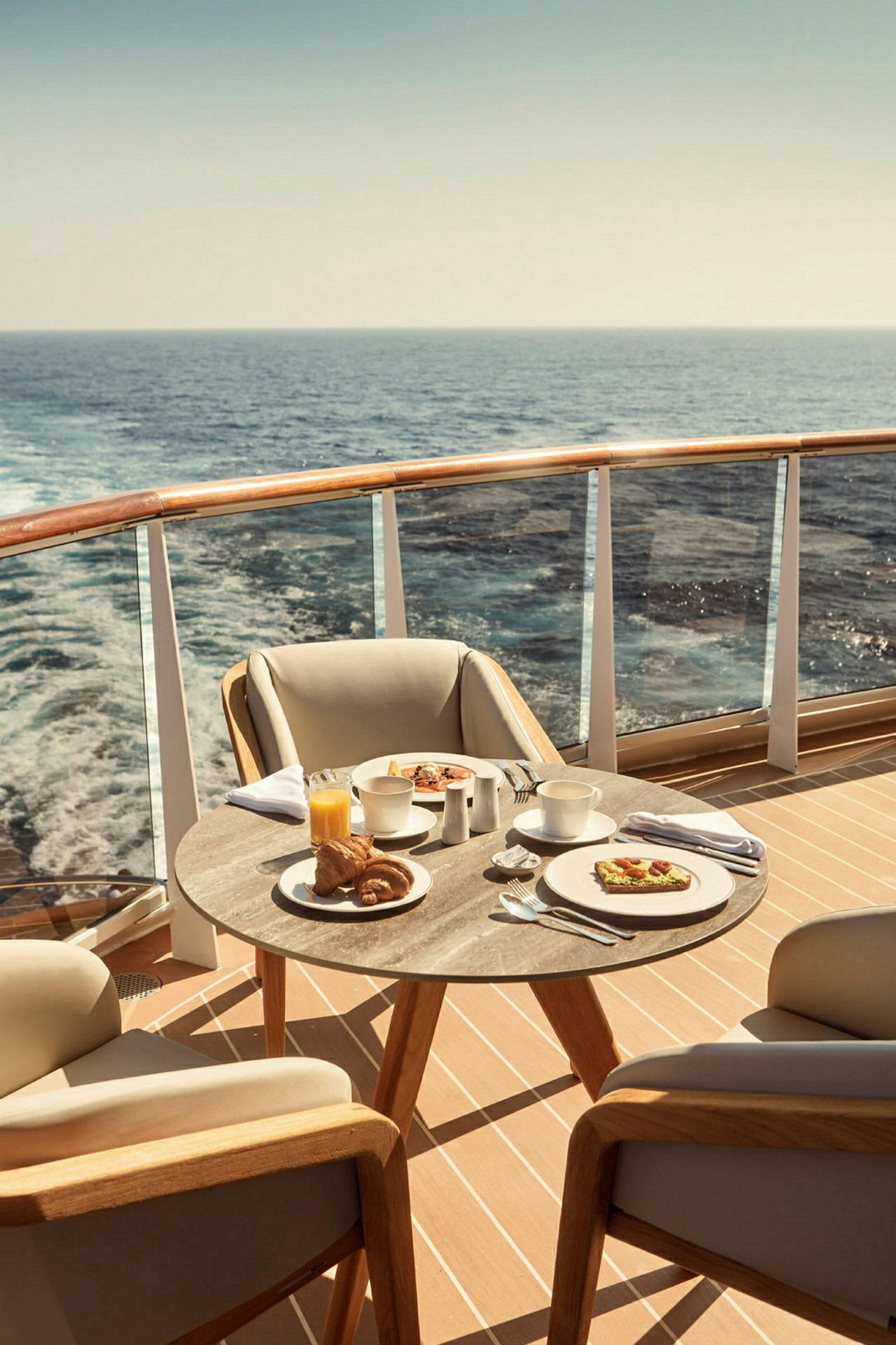 En frukost serverad på ett bord med två stolar på en uteplats vid havet. (AI-genererad text)