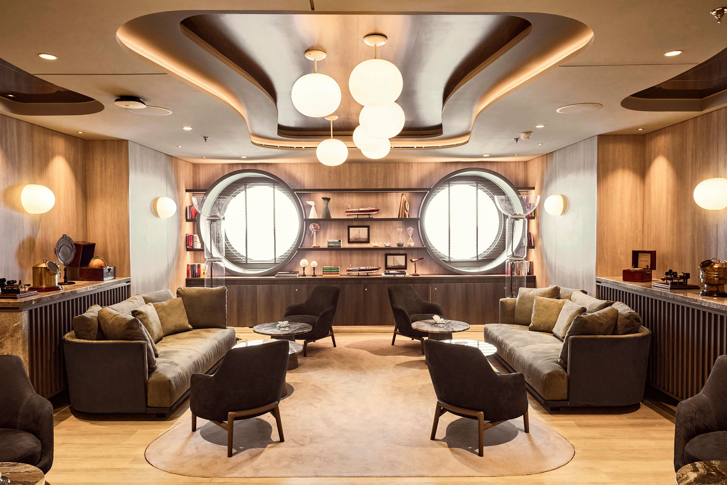 En elegant lounge med soffor, fåtöljer och runda fönster på väggarna. (AI-genererad text)