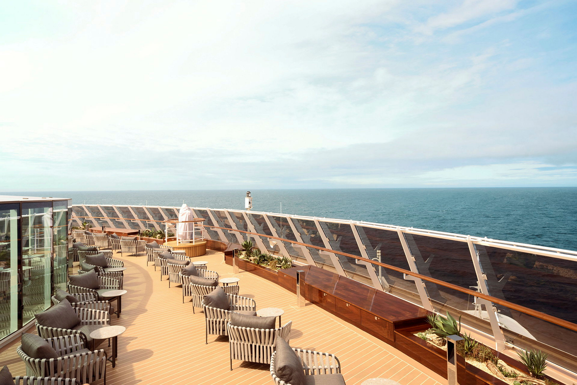 Bild på ett kryssningsfartygs utomhusdäck med sittplatser, solskydd och havet i bakgrunden. (AI-genererad text)