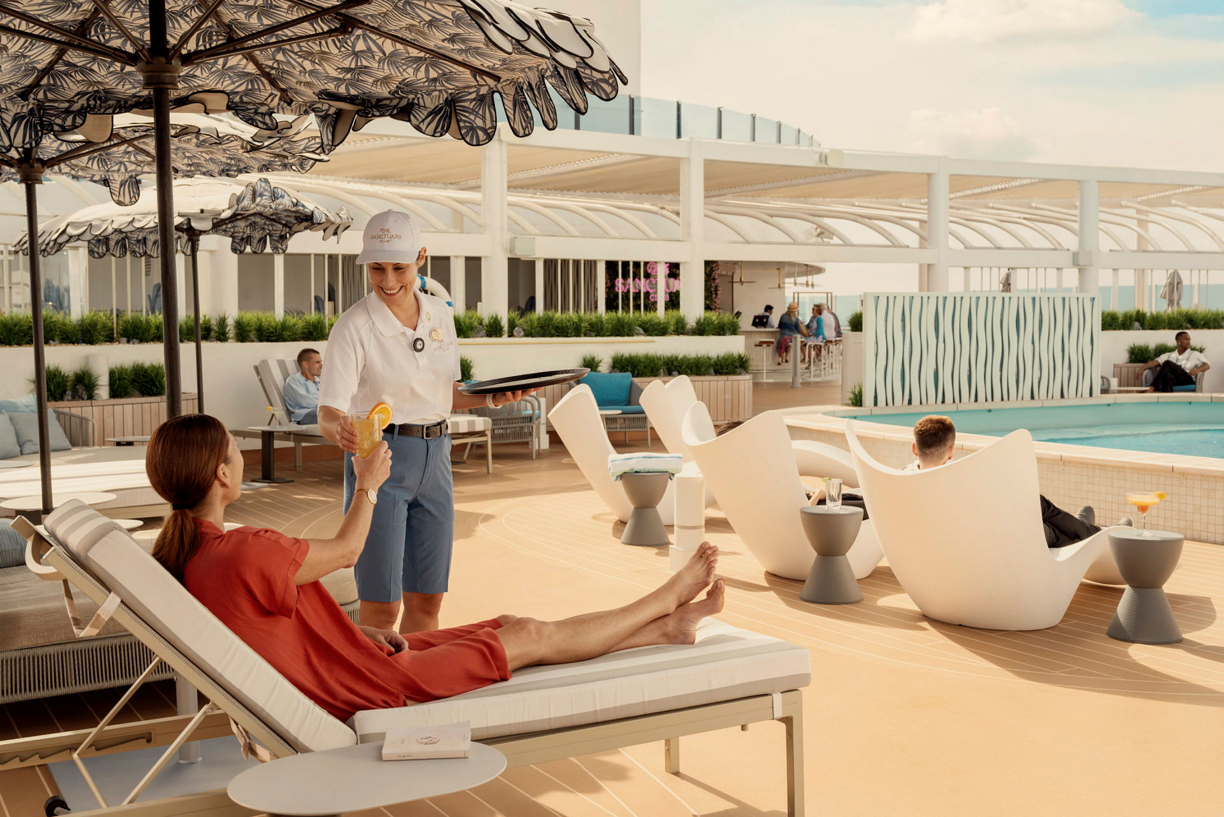 En person vid en pool som serveras en drink av en personal i uniform. (AI-genererad text)