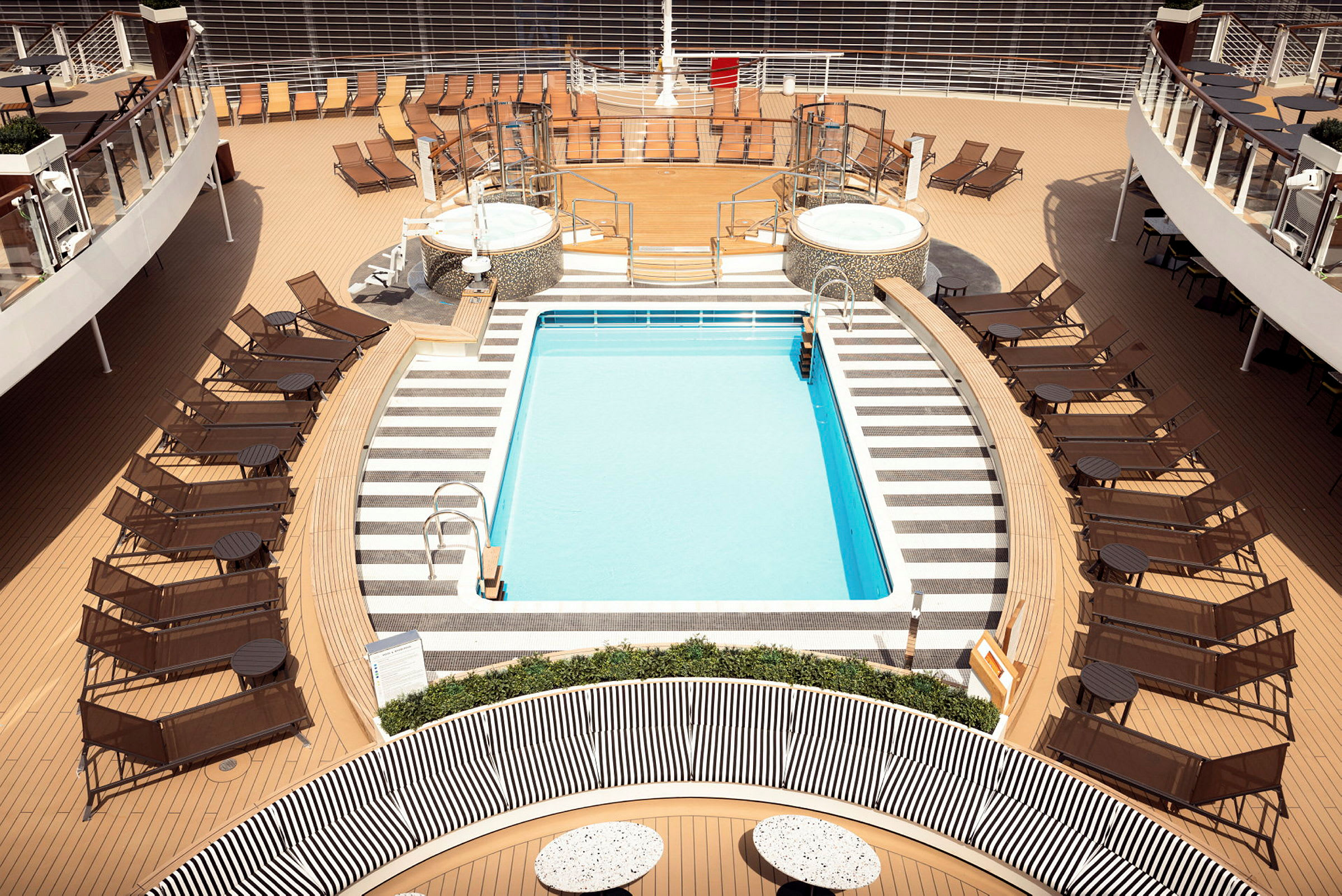 Bild på ett fartygsdäck med pool, solstolar och två jacuzzi. (AI-genererad text)